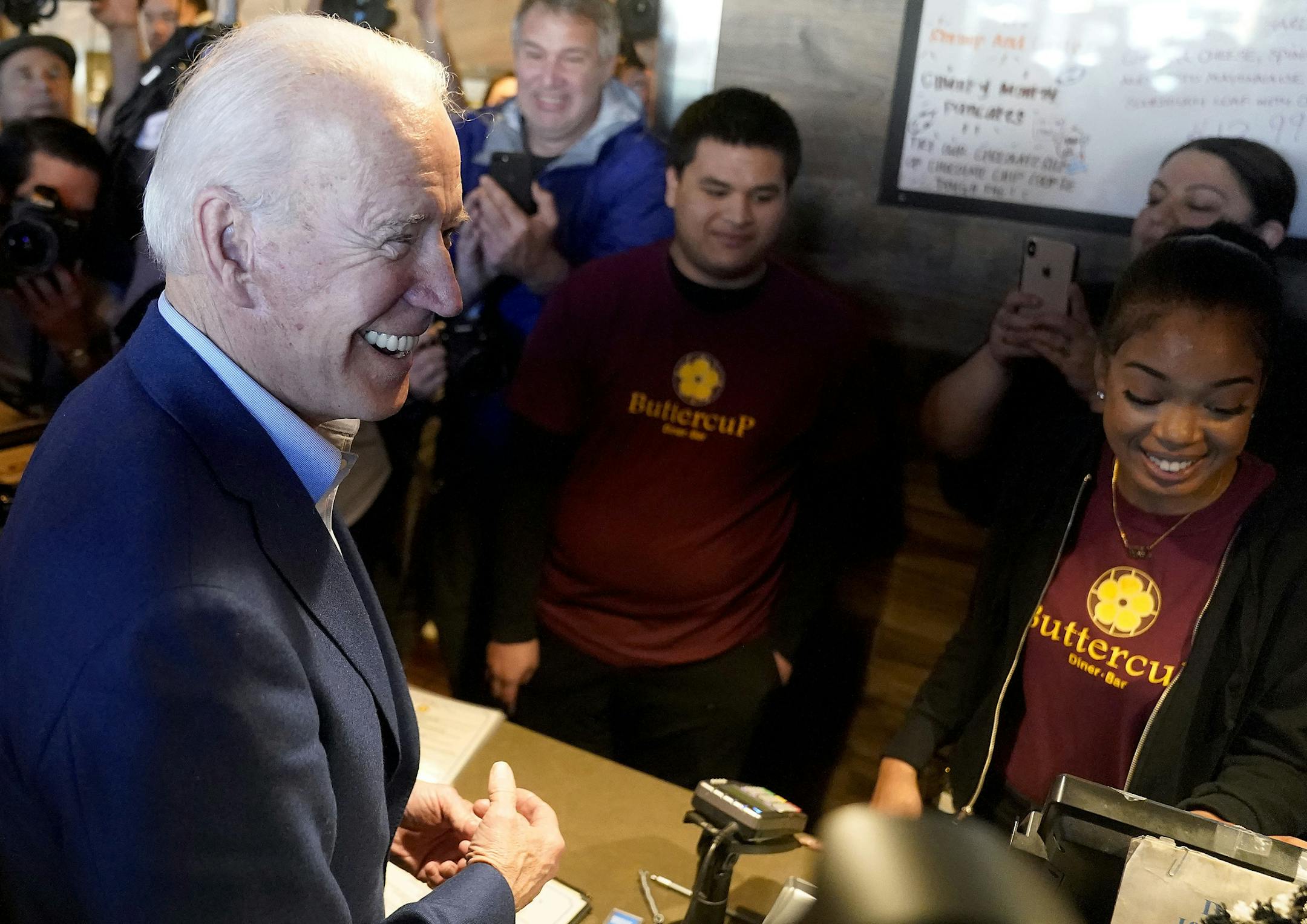 Democratic presidential candidate former Vice President Joe Biden, left, greets employees at the Buttercup Diner during a campaign stop in Oakland, Calif., Tuesday, March 3, 2020. (AP Photo/Tony Avelar)