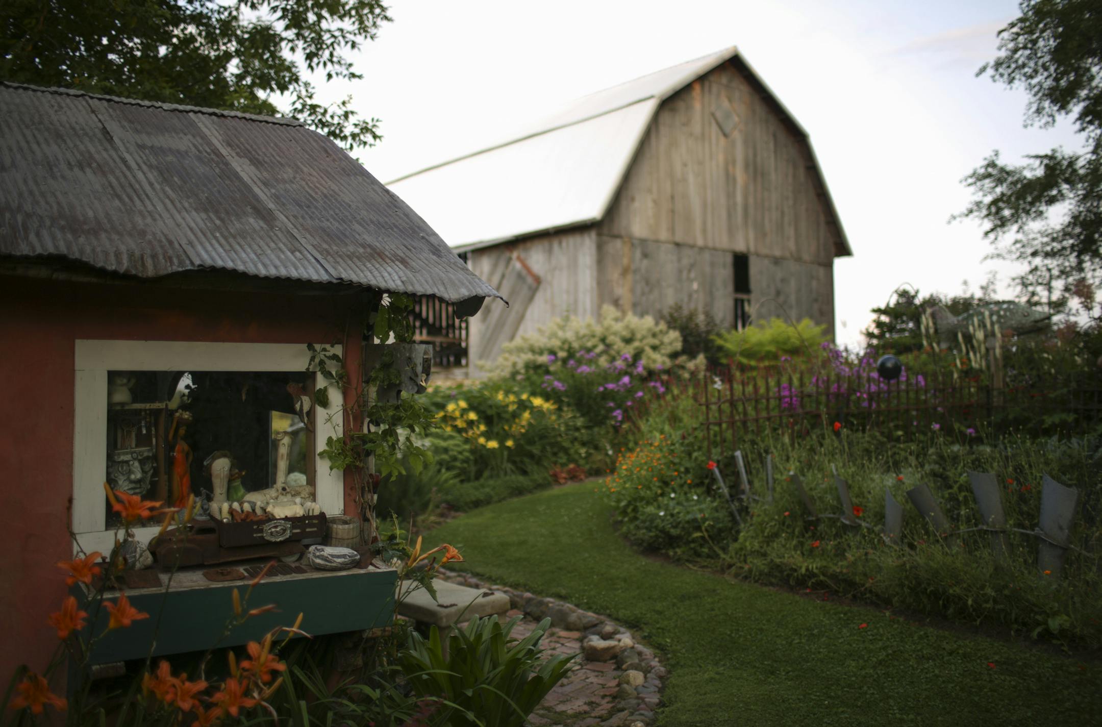 Flower beds and outbuildings in Wouterina de Raad's garden last summer. ] JEFF WHEELER ï jeff.wheeler@startribune.com Artist Wouterina de Raad's garden is a showcase for her concrete mosaic sculptures on her farm in Beldenville, WI. Her gardens were photographed Tuesday, July 29, 2014.