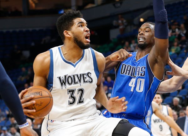 The Timberwolves' Karl-Anthony Towns, left, eyed the basket as he drove around the Mavericks' Harrison Barnes during the first quarter Monday.