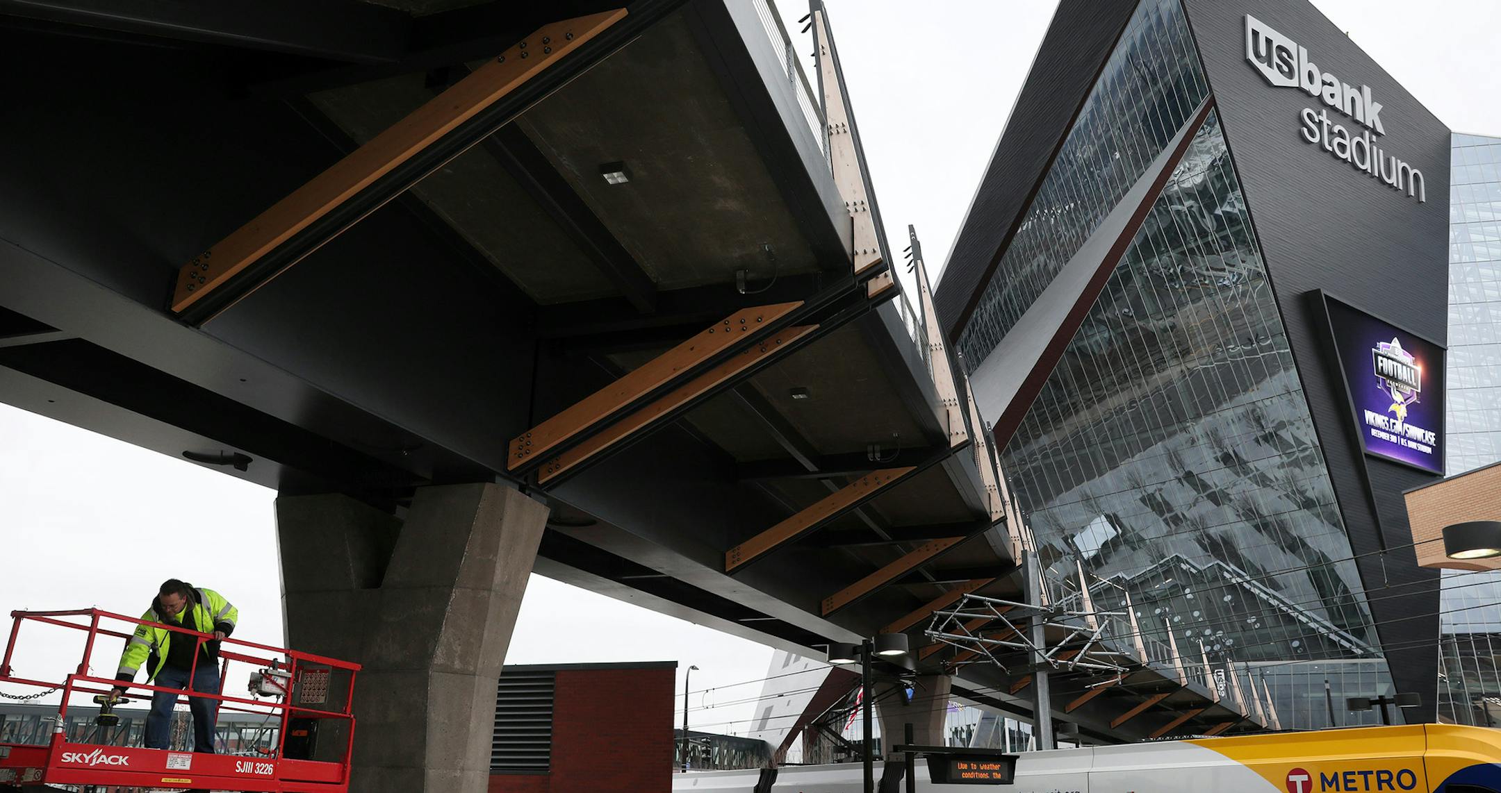 Tim Sibinski, a senior field technician with Systems Management & Balancing, works on the snow removal system underneath the pedestrian bridge to U.S. Bank Stadium Tuesday afternoon. ] ANTHONY SOUFFLE &#x2022; anthony.souffle@startribune.com Pictured is the pedestrian bridge to U.S. Bank Stadium seen Nov. 29, 2016 in Minneapolis. The $9.6 million pedestrian bridge went over budget due to problems with the elevator, and now the Metropolitan Council must make up the difference of about $60,000. OR