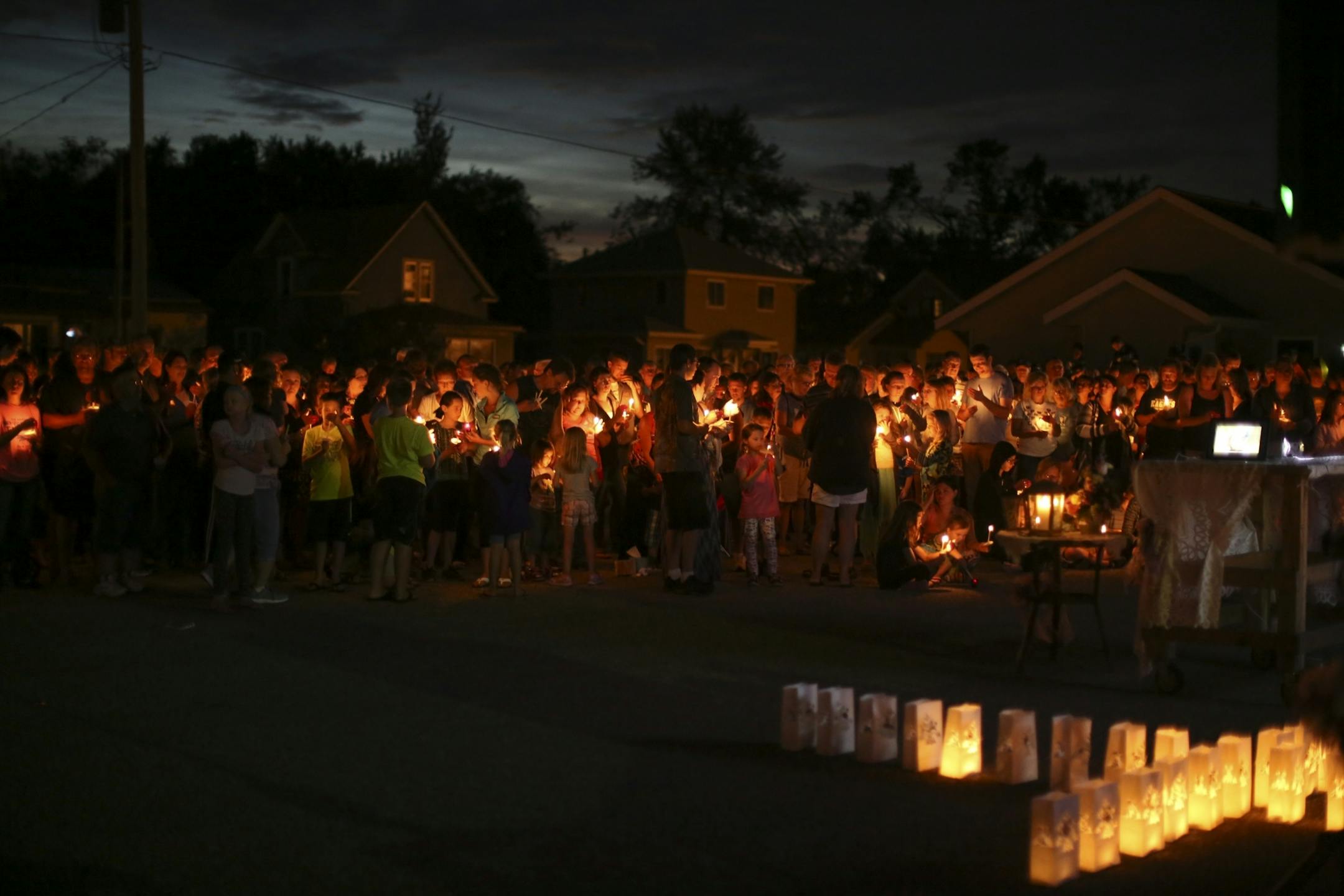 Mourners stood with their lit candles during the prayer vigil for Alayna Ertl Tuesday night in the parking lot of St. Anthony Church in Watkins.