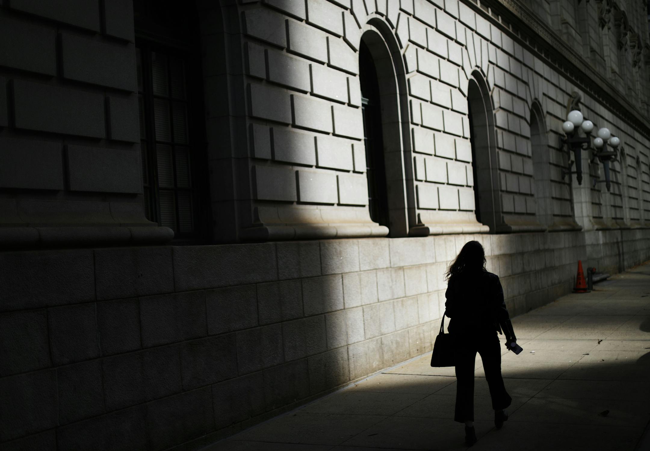 FILE - In this Dec. 3, 2018, file photo a pedestrian is silhouetted against a ray of sunlight hitting a downtown courthouse in Atlanta. In a world of information overload, it’s common to feel angst when making choices. You never know whether you’re making the best one. (AP Photo/David Goldman, File)