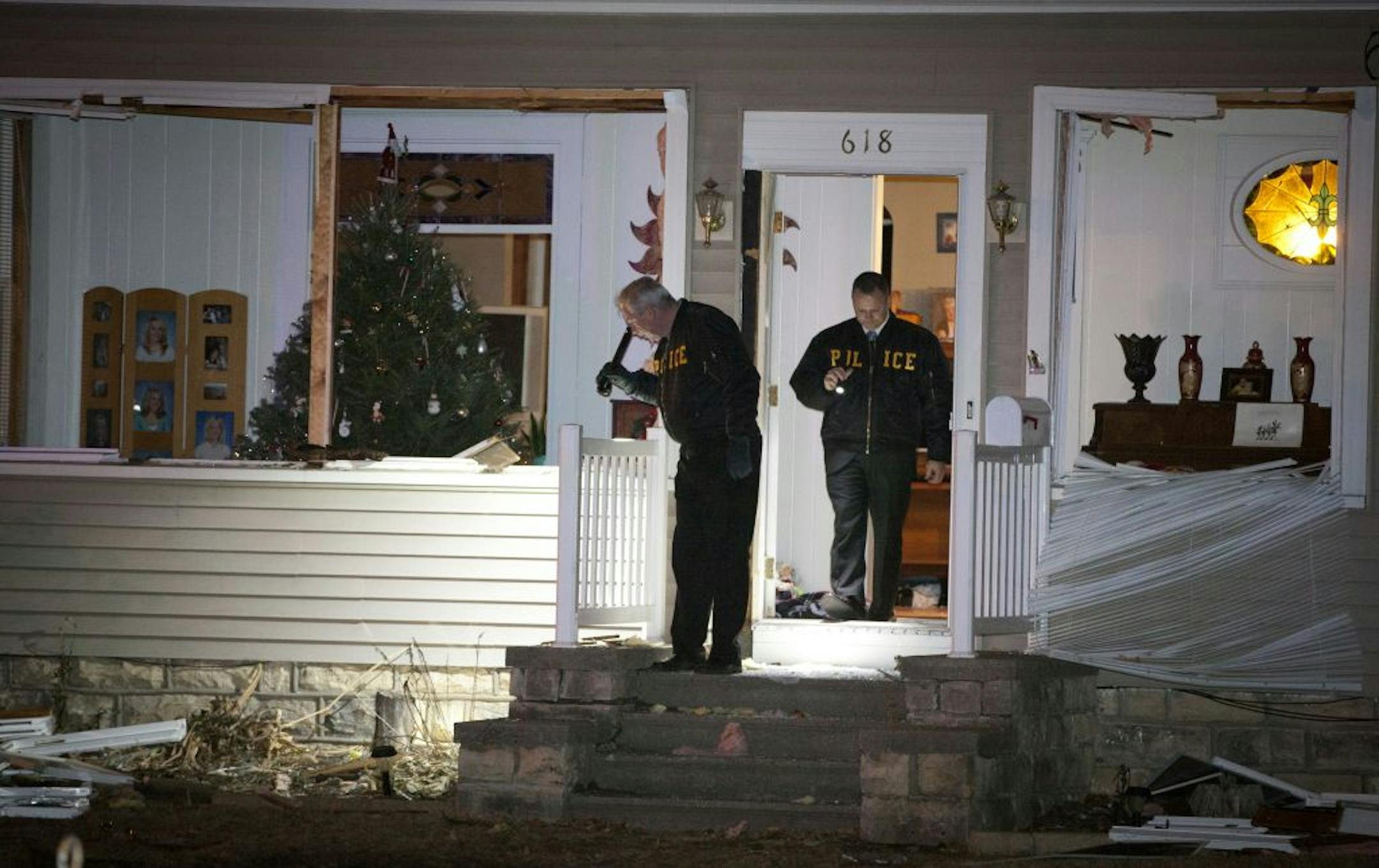 Officers from the Bureau of Criminal Apprehension examined the house where a Hager City, Wis., man had kept police at bay on Monday. The windows had been broken by police as a tactical procedure and robotic cameras used to look in each room.
