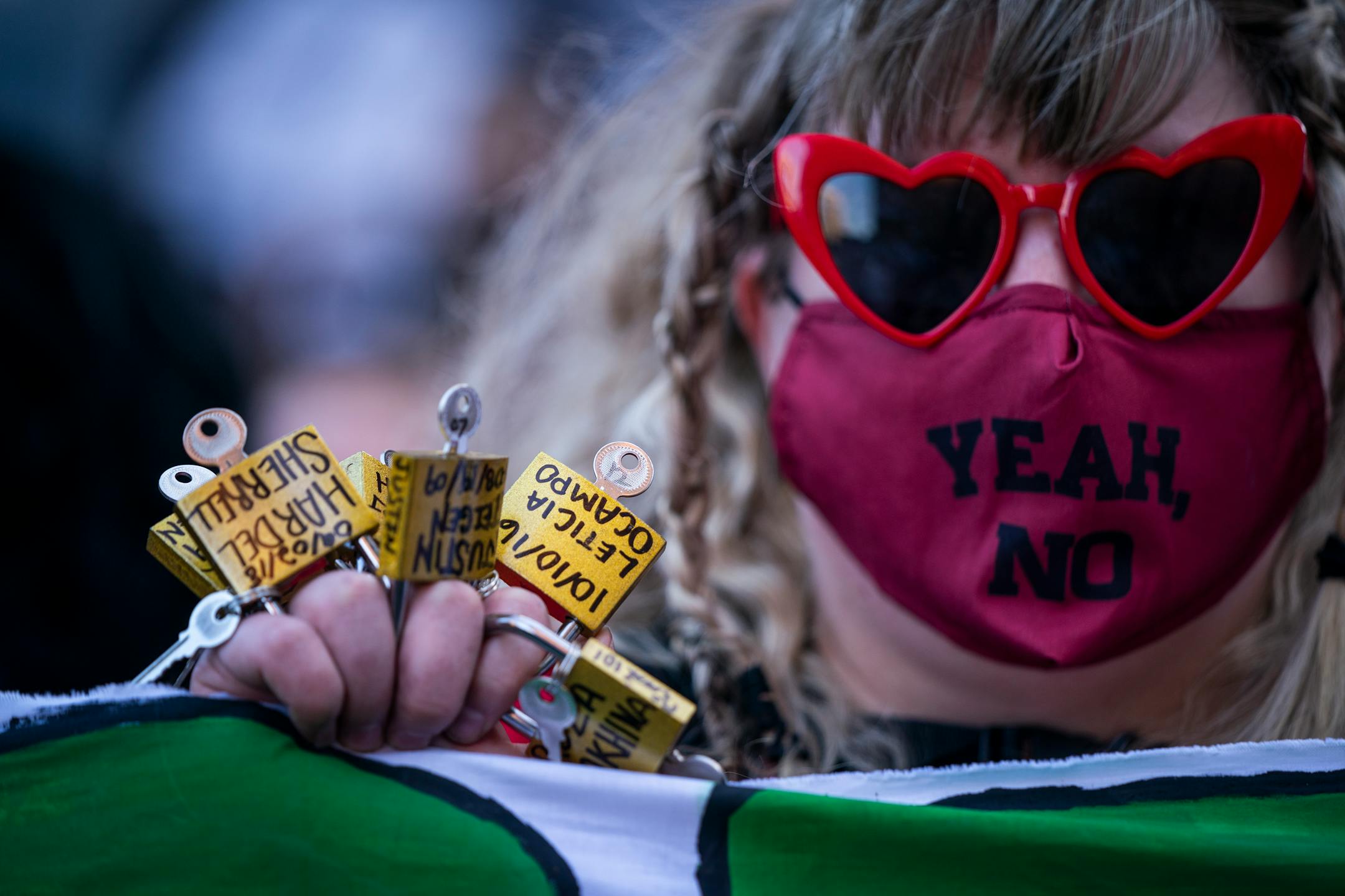 Emily Kringle of St. Paul held locks with the names of people killed by law enforcement during a rally and march on the first day of the Derek Chauvin murder trial in downtown Minneapolis.
