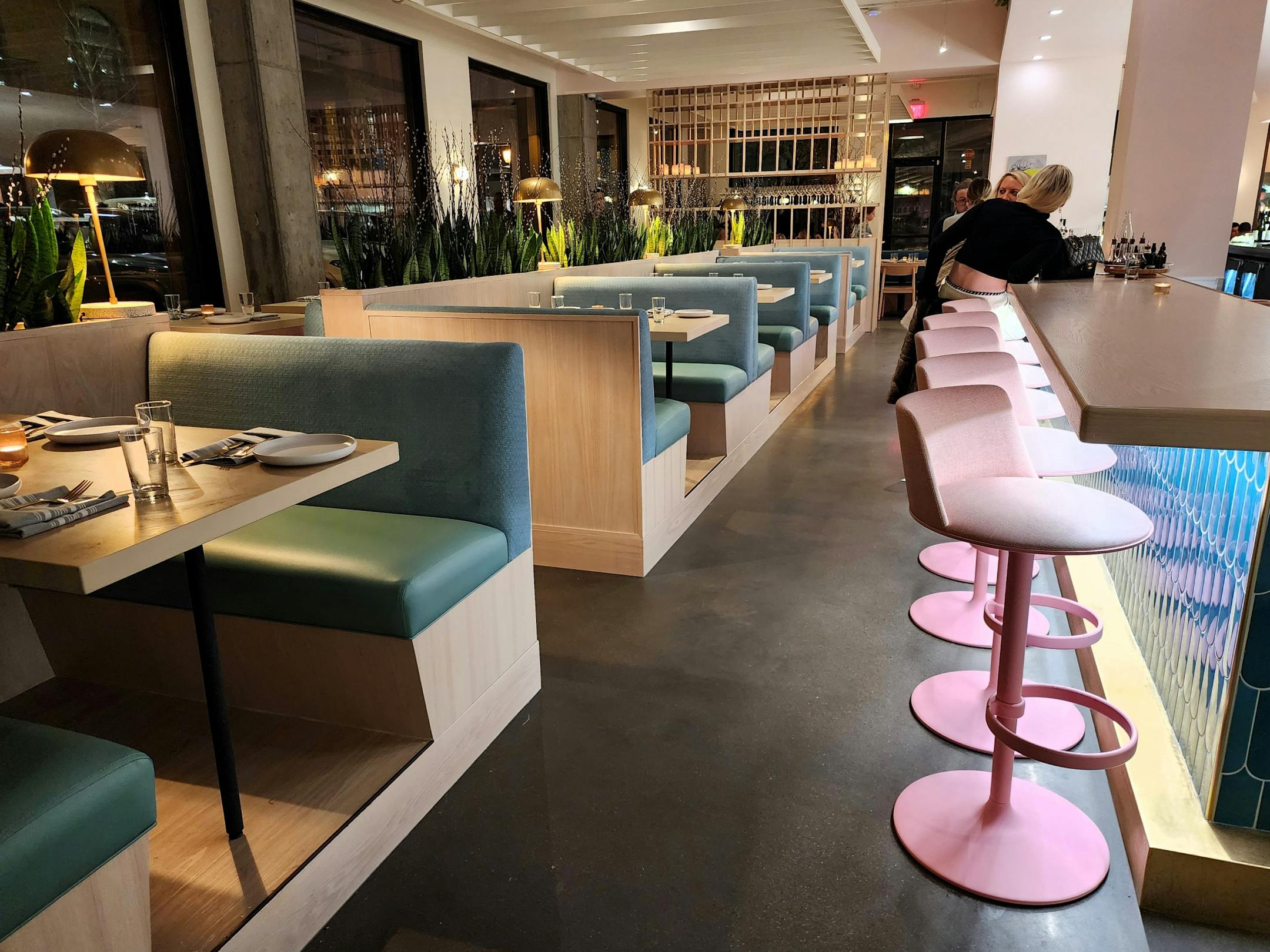 Pink barstools and light blue booths in the bar area