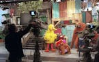FILE -- The characters Big Bird, Mr. Snuffleupagus and Baby Snuffleupagus with Annette Calud during the filming of an episode of PBS's "Sesame Street"