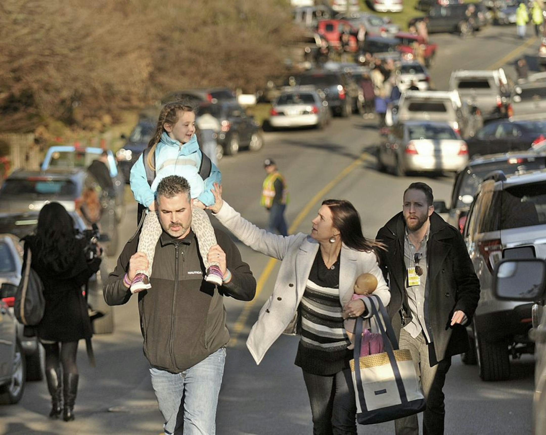 Parents leave Sandy Hook Elementary School in Newtown, Connecticut, with their children Friday, December 14, 2012. Twenty-seven people, including 18 children, have been killed in a shooting at Sandy Hook Elementary School.