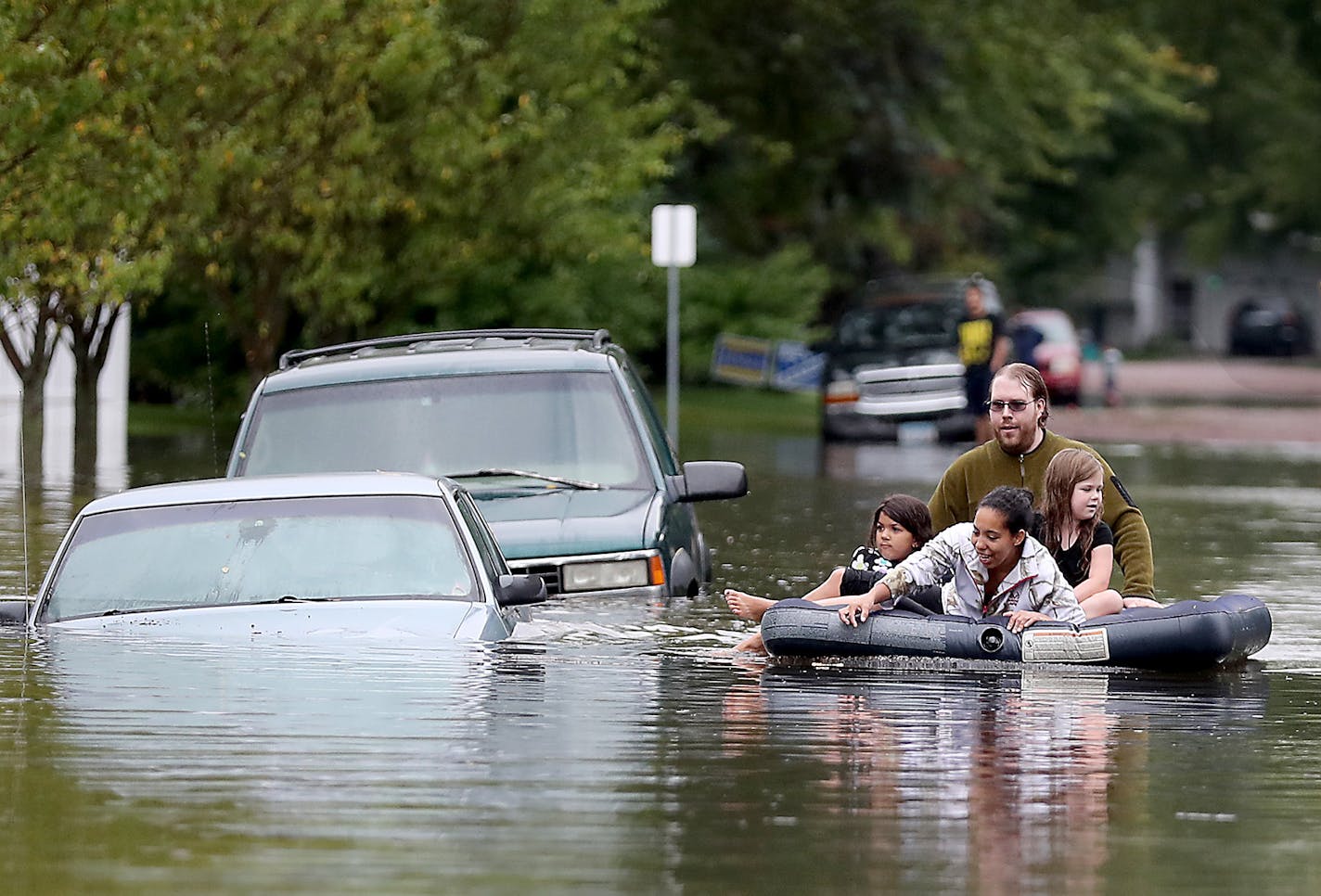 Ellery Forsythe pushed some kids on an air mattress to get a closer look at the submerged vehicles on a Waseca street, Thursday, September 22, 2016 in Waseca, MN. ] (ELIZABETH FLORES/STAR TRIBUNE) ELIZABETH FLORES &#x2022; eflores@startribune.com