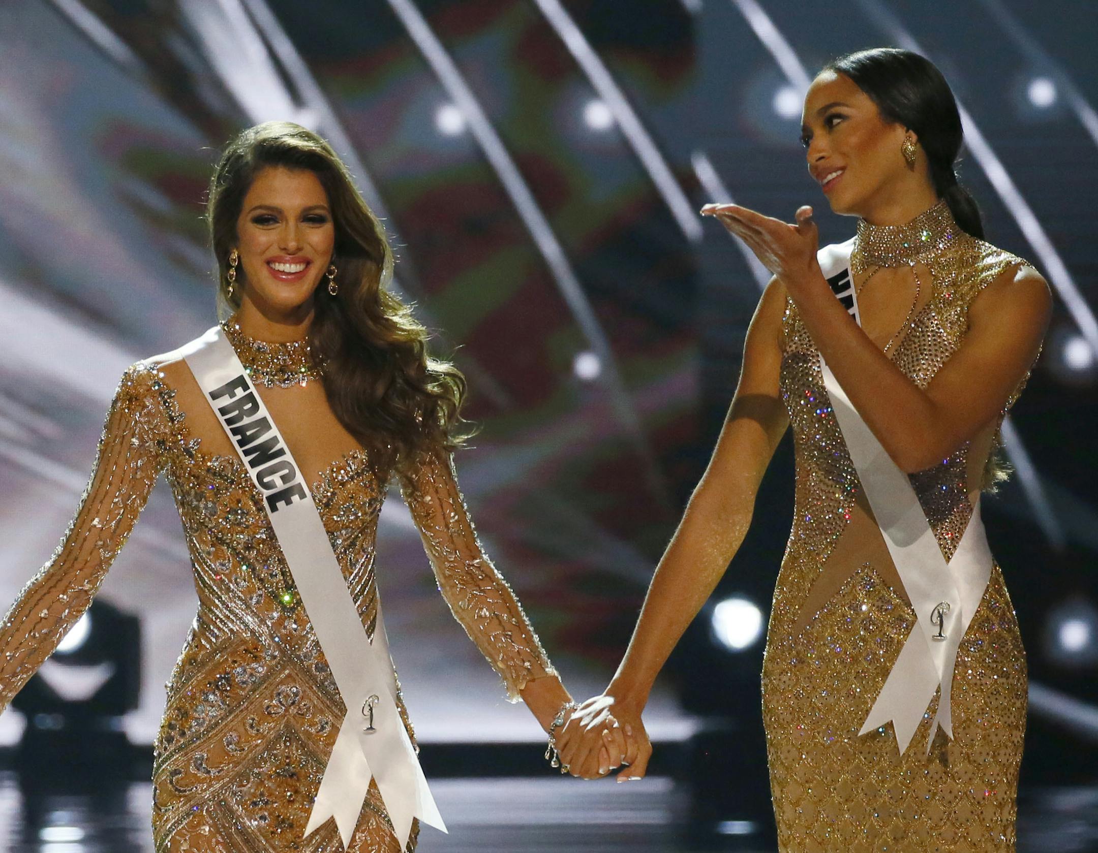 Miss Colombia Andrea Tovar, left, Miss France Iris Mittenaere, center, and Miss Haiti Raquel Pelissier hold hands prior to the announcement of the winner in the Miss Universe 2016 competition Monday, Jan. 30, 2017, at the Mall of Asia in suburban Pasay city, south of Manila, Philippines. Mittenaere was crowned the Miss Universe 2016, Raquel Pelissier was the runner-up and Tovar the 1st Runer-up. (AP Photo/Bullit Marquez)