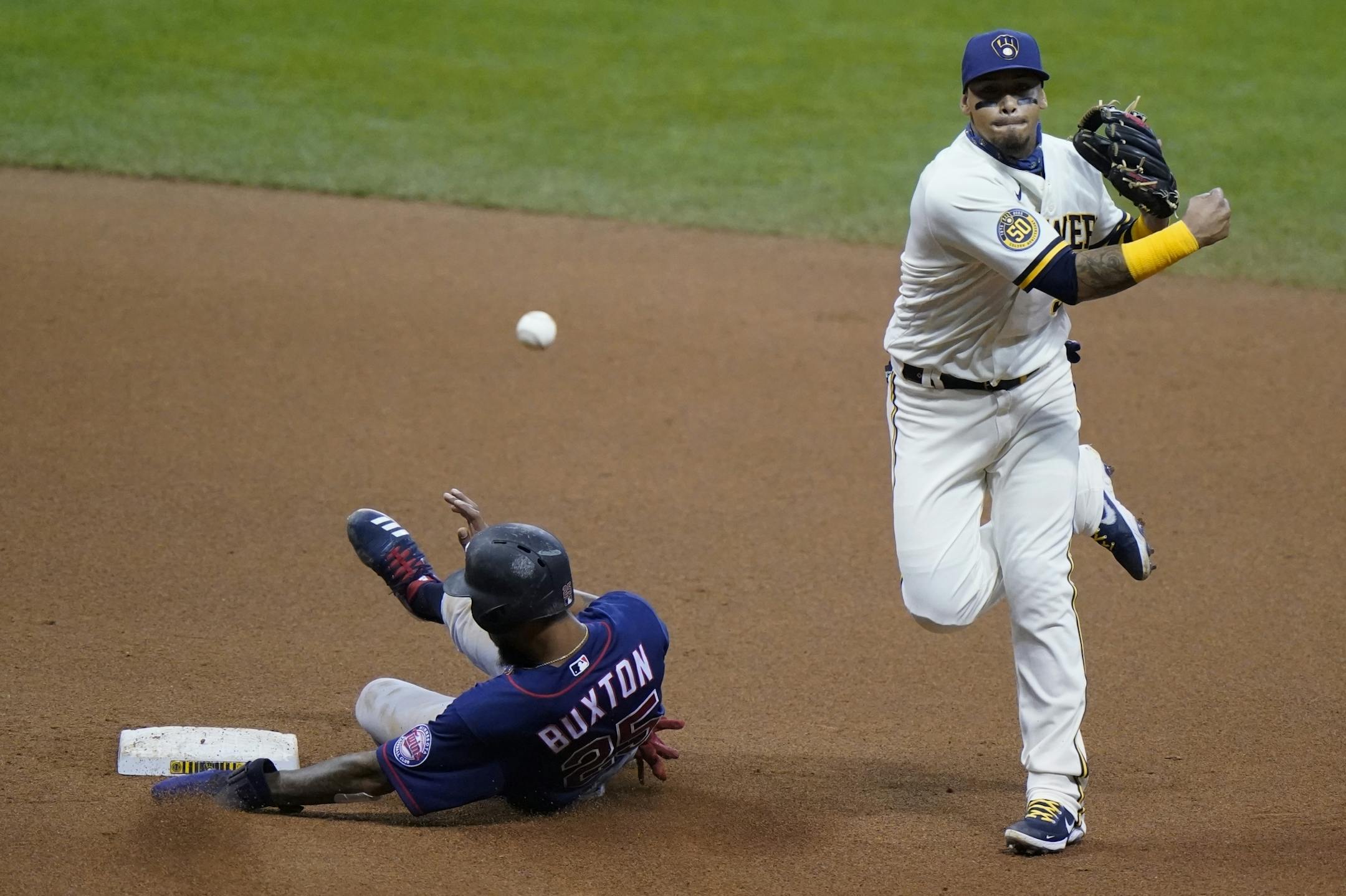 Minnesota Twins' Byron Buxton is out at second as Milwaukee Brewers' Orlando Arcia turns a double play on a ball hit by Jorge Polanco during the sixth inning of a baseball game Tuesday, Aug. 11, 2020, in Milwaukee.