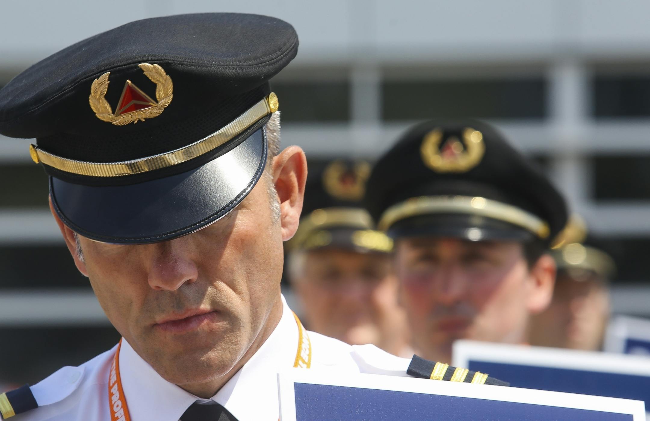 A Delta Air Lines pilot bows his head while marching for over an hour outside.