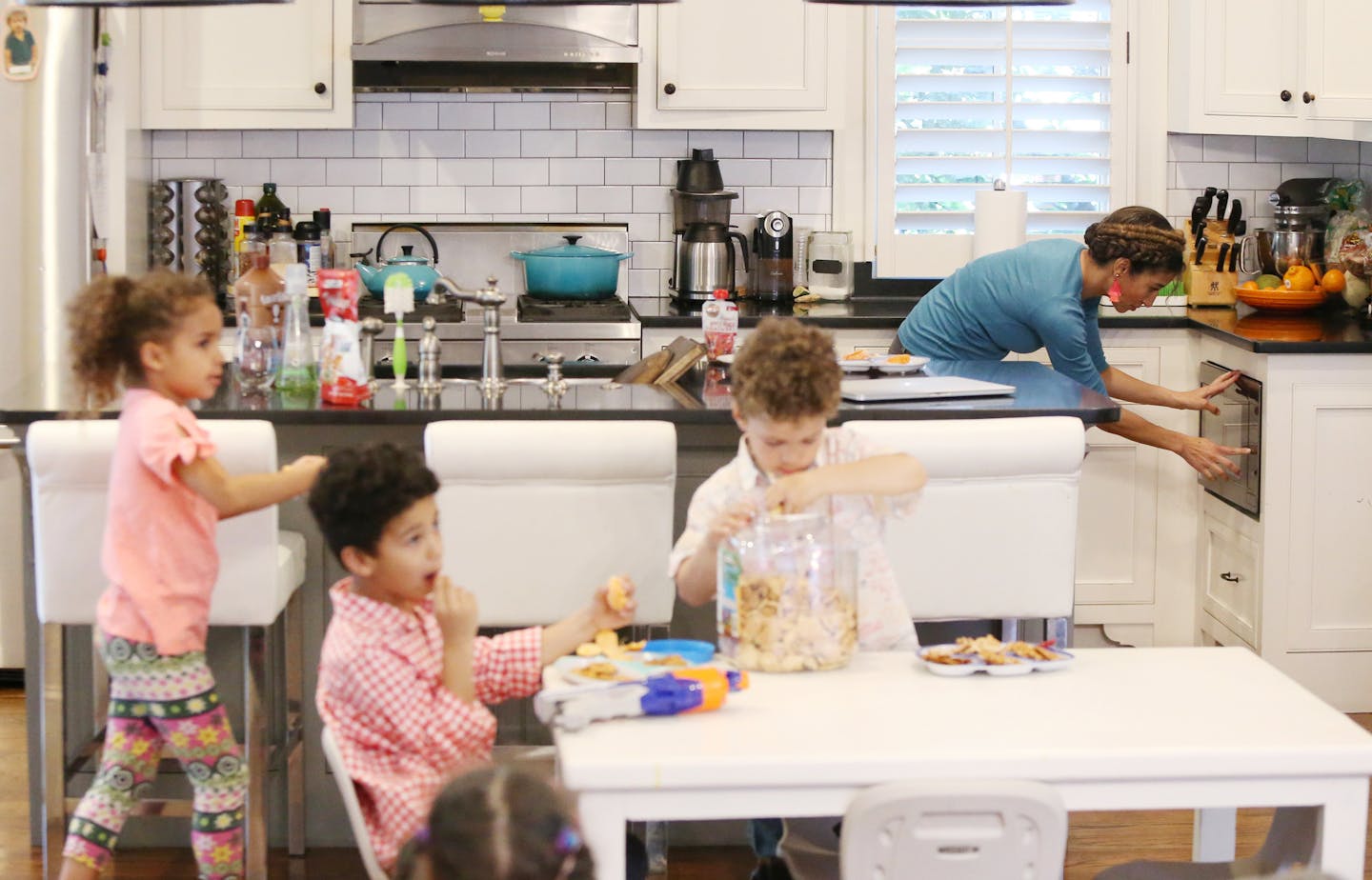 Debra Shigley heats up food for her youngest child while the four other children enjoy a snack and a movie in their home after playing outside in Atlanta, Ga., on Friday, March 22, 2019. (Emily Haney/Atlanta Journal-Constitution/TNS)