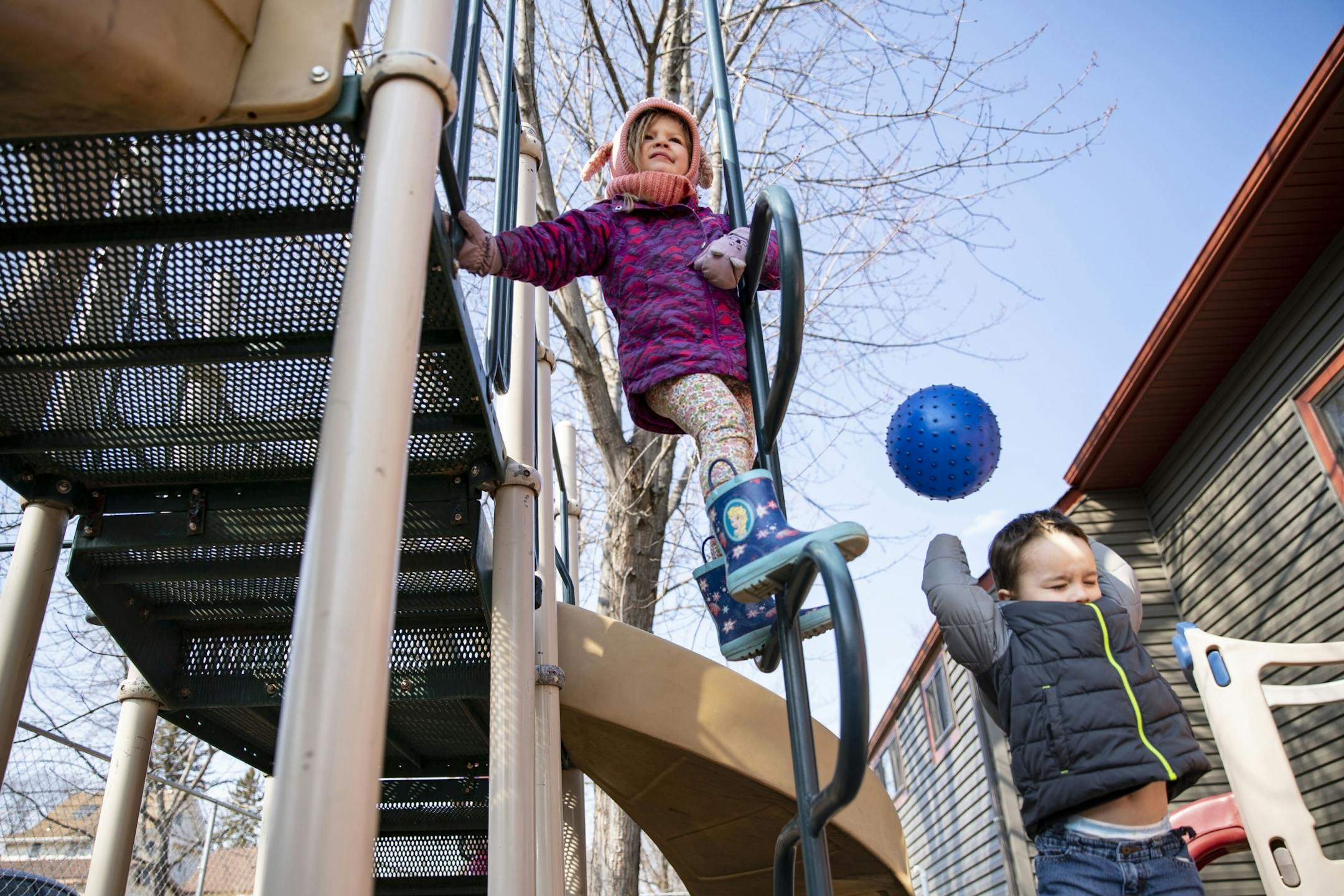Nola, left, climbed on a playground while William threw a ball over his head during playtime at Aunty's Child Care in Duluth, MN on Thursday.