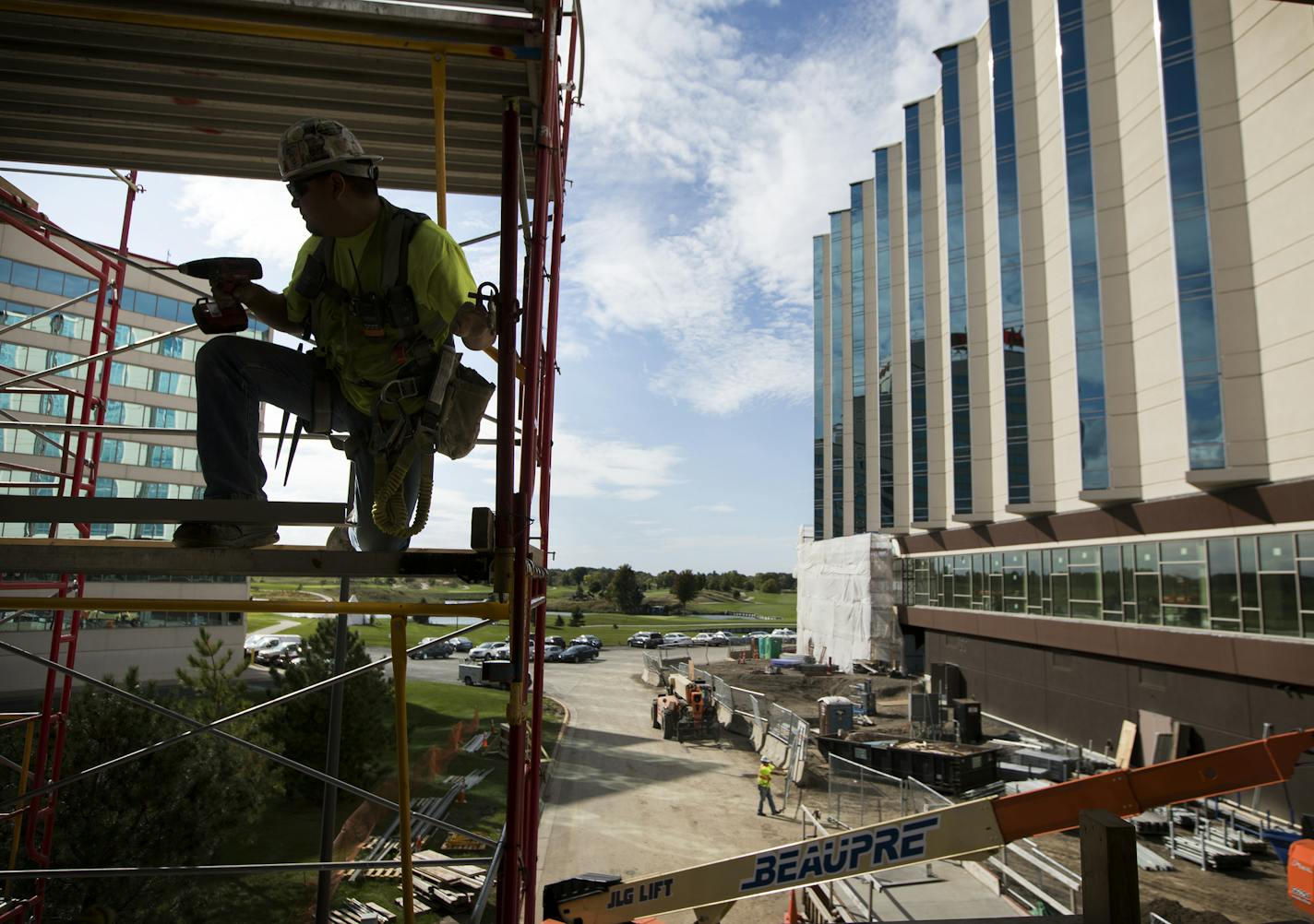 The exterior of Mystic Lake Center is seen on the right as a construction worker works on scaffolding in the skyway entrance area. ] LEILA NAVIDI &#xef; leila.navidi@startribune.com BACKGROUND INFORMATION: A media hard hat tour of the new Mystic Lake Center at Mystic Lake Casino Hotel in Prior Lake on Thursday, September 28, 2017.