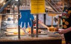 Customers wore mandatory masks and were offered disposable gloves to use at the self-serve buffet area at the Golden Coral Buffet and Grill. ] LEILA N