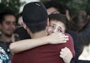 Two people comfort each other at the funeral of elementary school principal Elsa Mendoza, of one of the 22 people killed in a shooting at a Walmart in