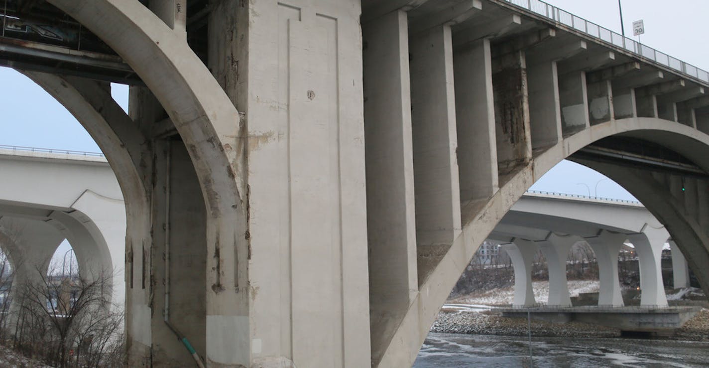 The 10th Avenue Bridge over the Mississippi River in Minneapolis, with the I-35W Bridge to the rear .