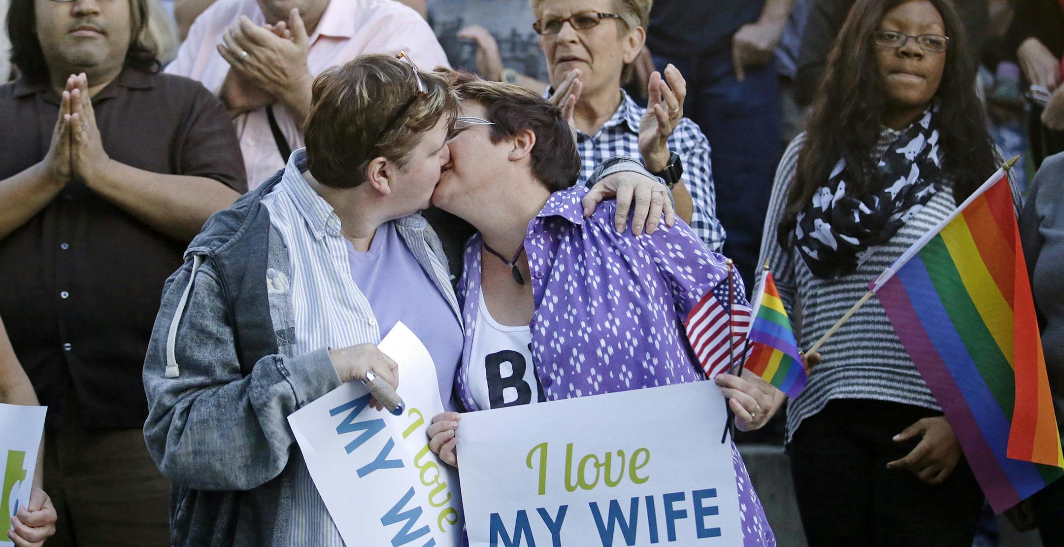 FILE - In this Monday, Oct. 6, 2014, file photo, married couple Penny Kirby, left, and Terri Henry kiss during a gay marriage rally in Salt Lake City. The U.S. Supreme Court's decision not to take an appeal of Utah's gay marriage case means that a parallel lawsuit brought by gay and lesbian couples who sued the state over its decision not to recognize their marriages has been resolved too. (AP Photo/Rick Bowmer, File) ORG XMIT: MIN2014100715191956