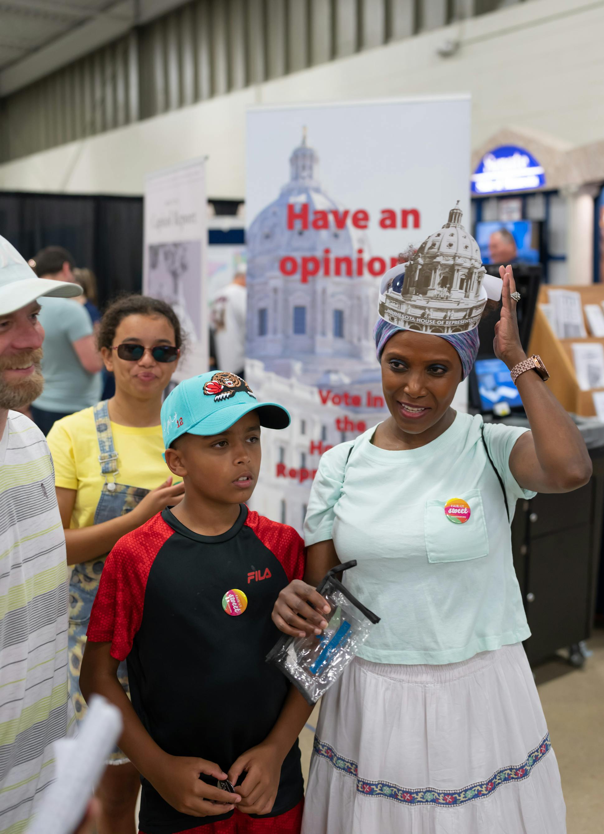 Tigist Opheim wore a Minnesota House of Representatives hat at the House display in the State Fair’s Education Building. She visited the exhibit on Aug. 26 with her husband, Tom, left, and their two children, Tinsae, 14, and Tommy, 10.