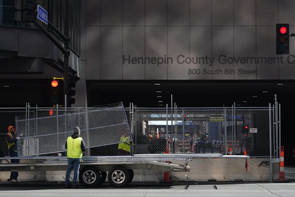 Crews with Hansen Bros Fence positioned concrete barriers, chain link fence and concertina wire around the Hennepin County Public Safety Facility, Hen