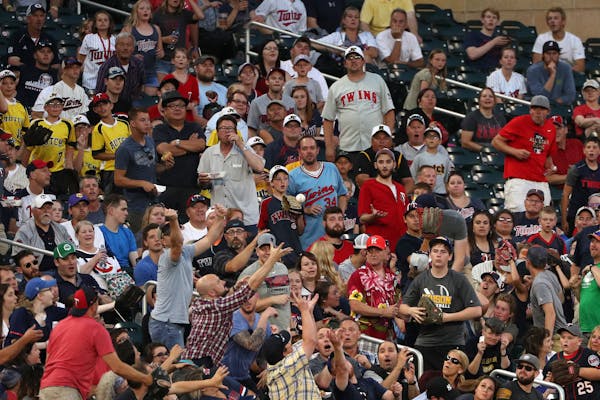 Fans reached out to grab a foul ball during a game last season at Target Field.