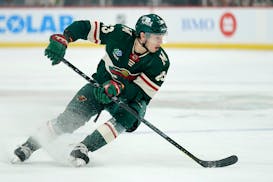 Minnesota Wild center Marco Rossi (23) skates with the puck during the first period of an NHL preseason hockey game against the Dallas Stars, Saturday
