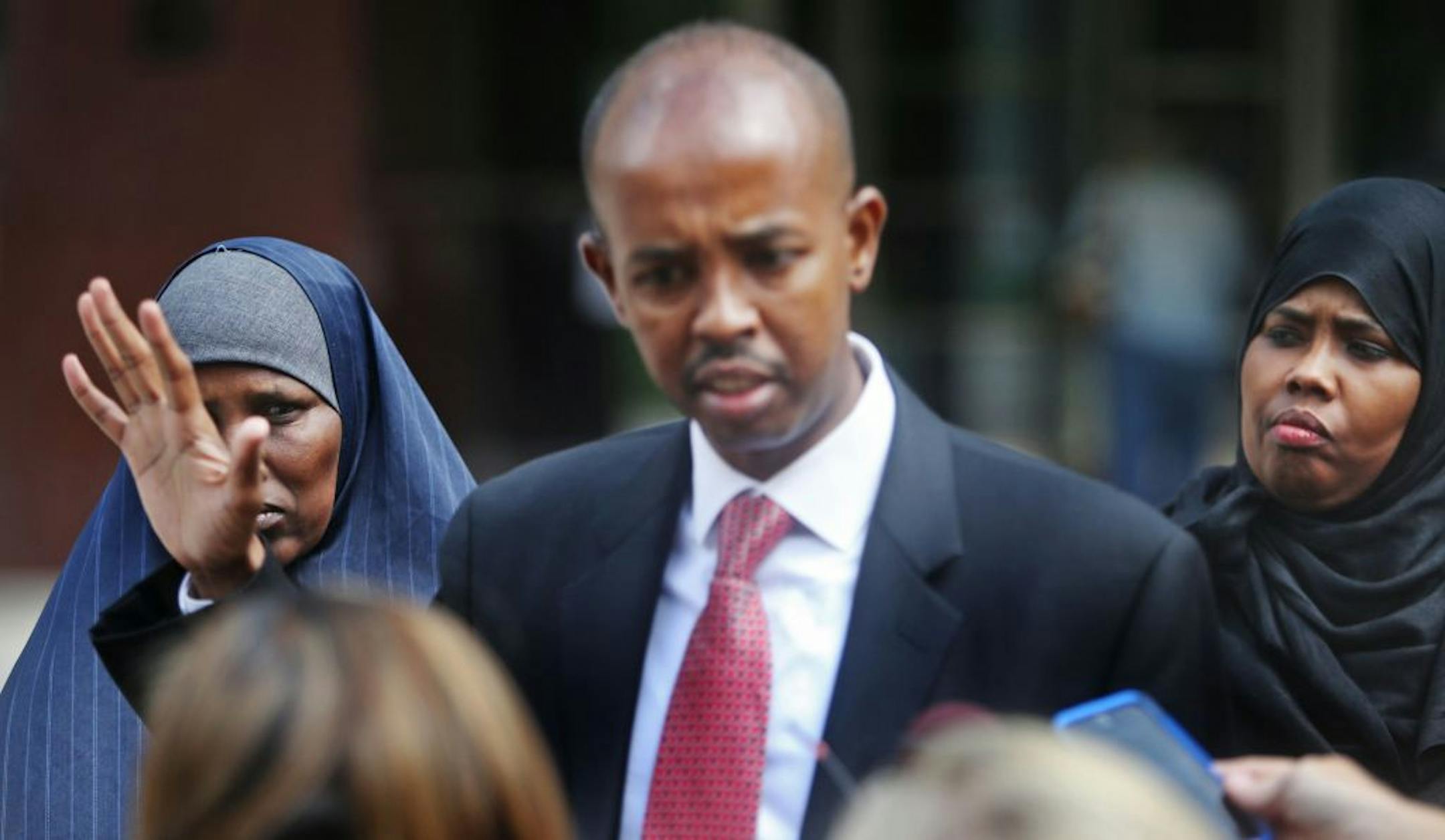 Somali community spokesperson Sadik Warfa addressed media members after three local men accused of conspiring to leave the country to join ISIL were denied a bid for pretrial release Wednesday, July 8, 2015, outside the Federal Courthouse in Minneapolis. Looking on are mothers of two of the three men.
