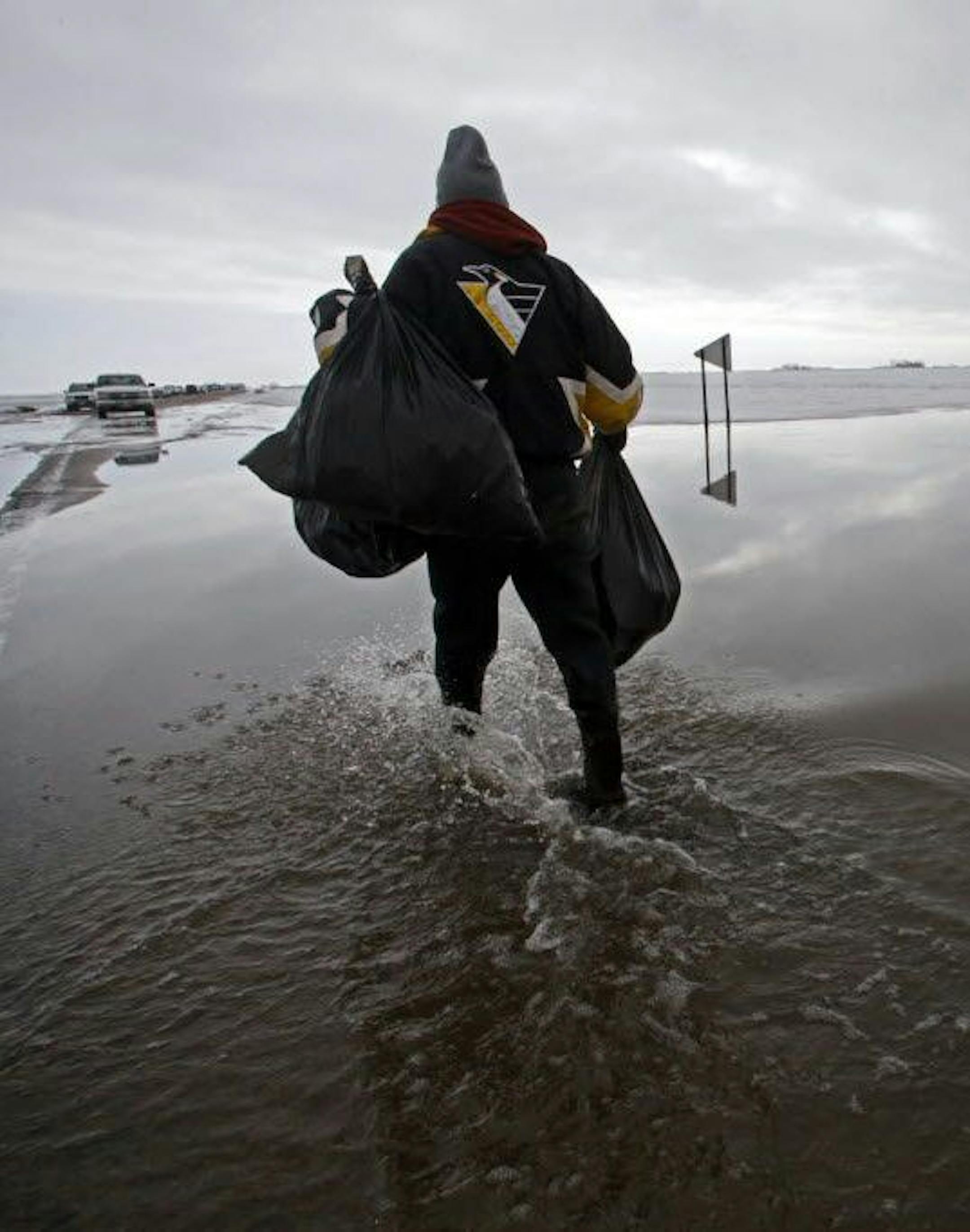 The 2009 Red River flood broke records and isolated Fargo-Moorhead residents in their homes. Here, John Schultz wades through the frigid water that surrounded his home in the Crestwood subdivision.