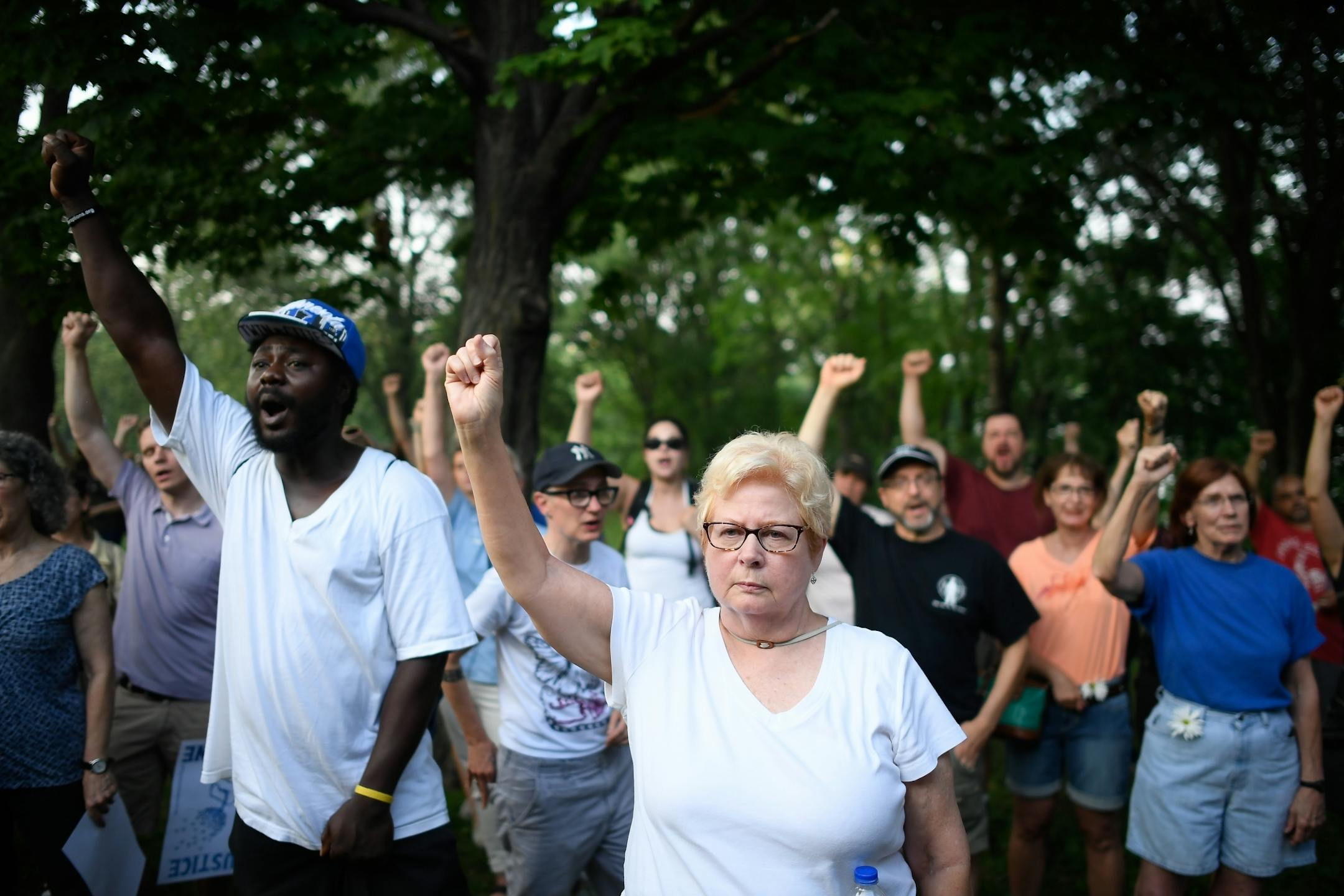 Jan Skogstrom, of Minneapolis, raised her fist with fellow protesters during the Peace and Justice March for Justine at Beard's Plaissance Park Thursday night.