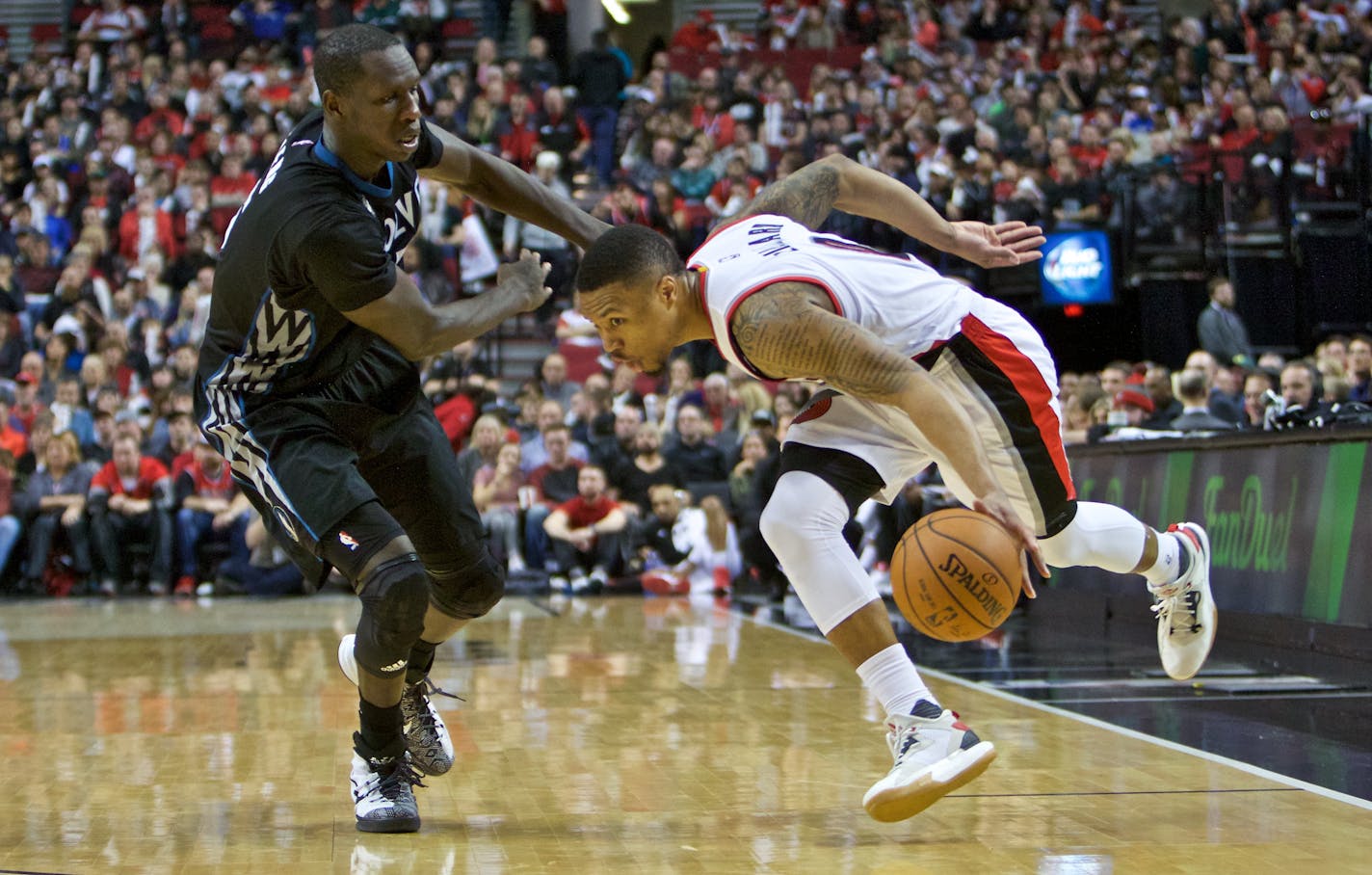 Portland guard Damian Lillard, right, dribbled around Timberwolves center Gorgui Dieng during the second half of Sunday night's game. The Trail Blazers won 96-93.