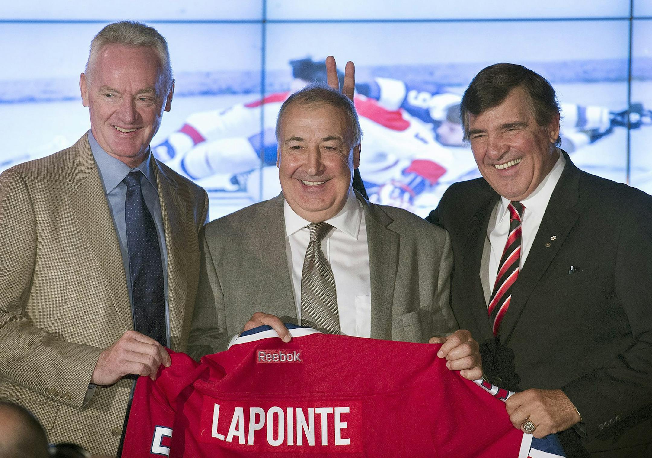 The Montreal Canadiens' Big 3, from left, Larry Robinson, Guy Lapointe, and Serge Savard, making bunny ears, smile during the news conference announcing the retirement of Lapointe's jersey at the Canadiens' Hall of Fame in Montreal, Thursday, June 19, 2014. Lapointe was inducted in the Hockey Hall of Fame in 1993. (AP Photo/The Canadian Press, Graham Hughes)