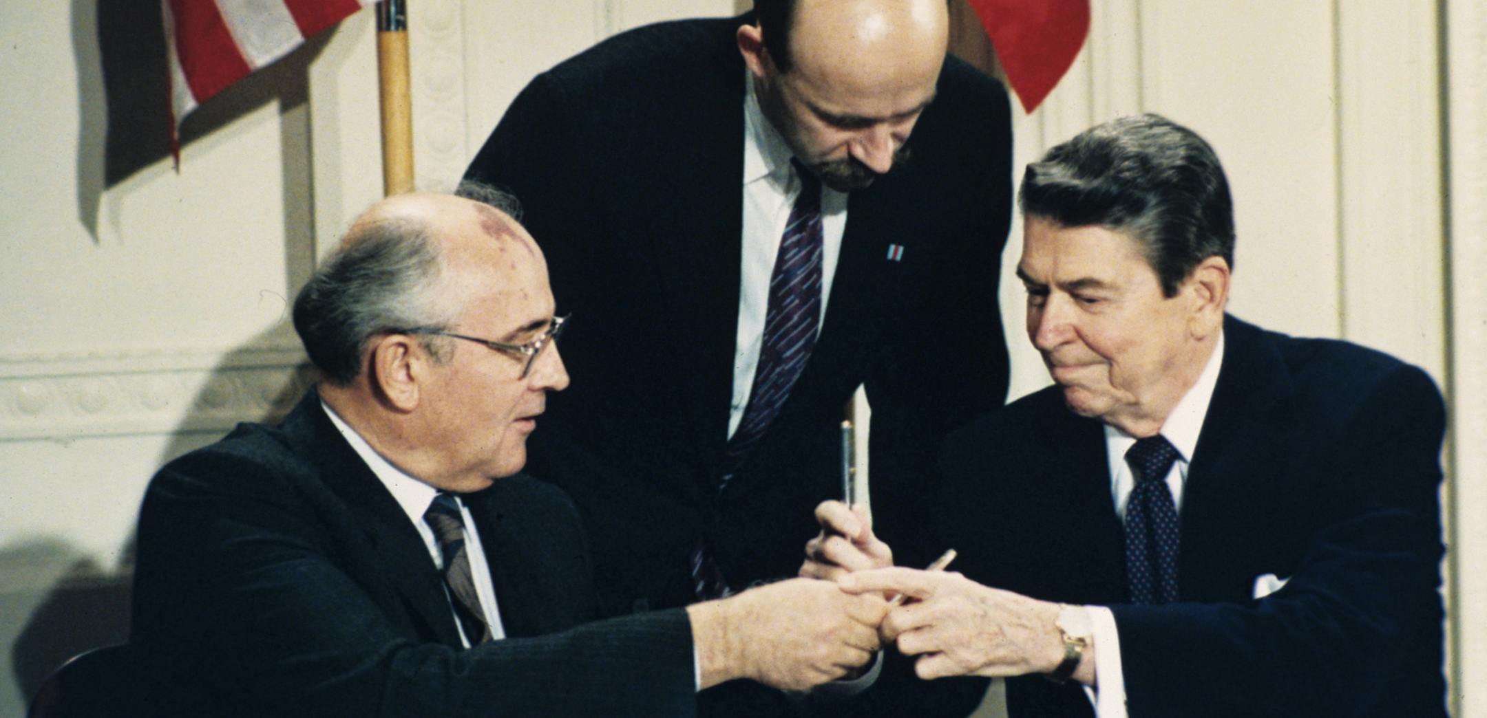 FILE - In this Dec. 8, 1987 file photo U.S. President Ronald Reagan, right, and Soviet leader Mikhail Gorbachev exchange pens during the Intermediate Range Nuclear Forces Treaty signing ceremony in the White House East Room in Washington, D.C. Gorbachev's translator Pavel Palazhchenko stands in the middle. Trump's announcement that the United States would leave the Intermediate-Range Nuclear Forces, or INF, treaty brought sharp criticism on Sunday Oct. 21, 2018, from Russian officials and from f