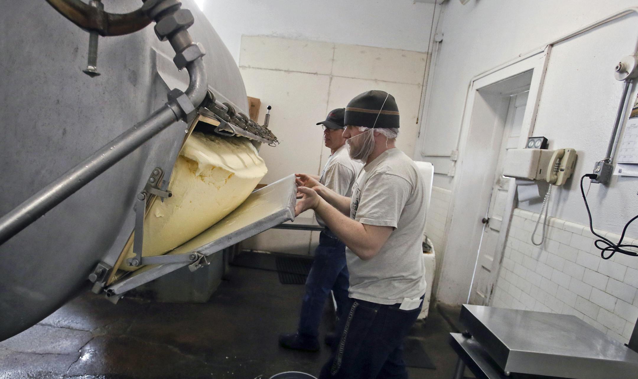 Following a lengthy churning process, packager Cody Blouin, front, and plant manager Jay Logan opened the door on the butter churner, revealing hundreds of pounds of the creamy butter before it was wrapped into 1-pound blocks at Hope Creamery in Hope, Minn, on Thursday.