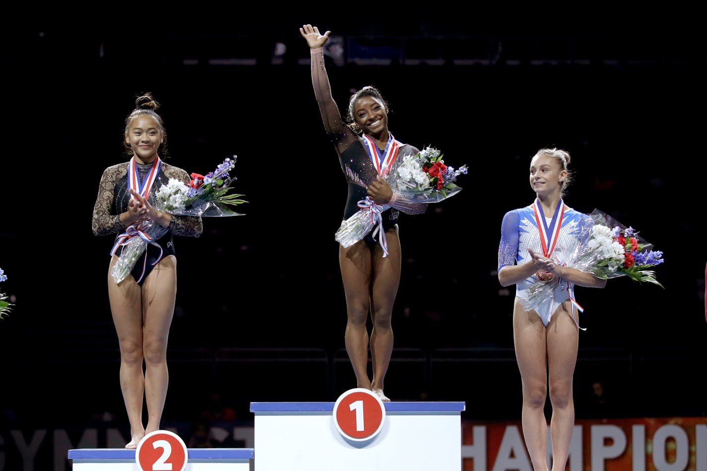 Several local Olympic hopefuls, including Suni Lee of St Paul (left) and Grace McCallum of Isanti (right, next to all-around winner Simone Biles at the 2019 U.S. Gymnastics Championships) are in limbo as qualifying events for the Tokyo Games have been disrupted by the spread of the coronavirus.