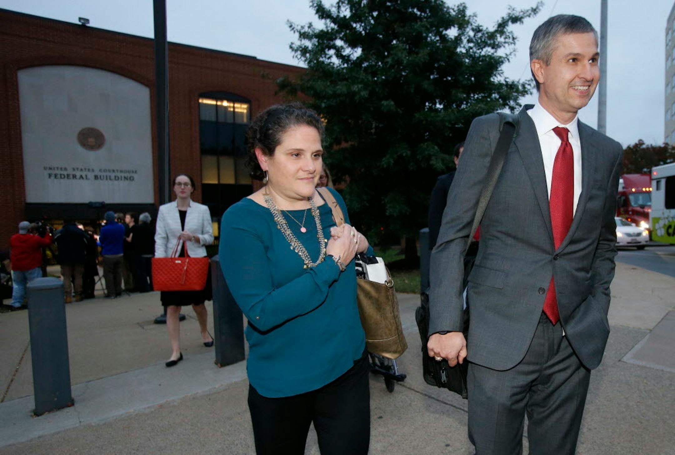 University of Virginia administrator Nicole Eramo, center, leaves federal court with her attorney Tom Clare, right, after closing arguments in her defamation lawsuit against Rolling Stone magazine in Charlottesville, Va., Tuesday, Nov. 1, 2016.