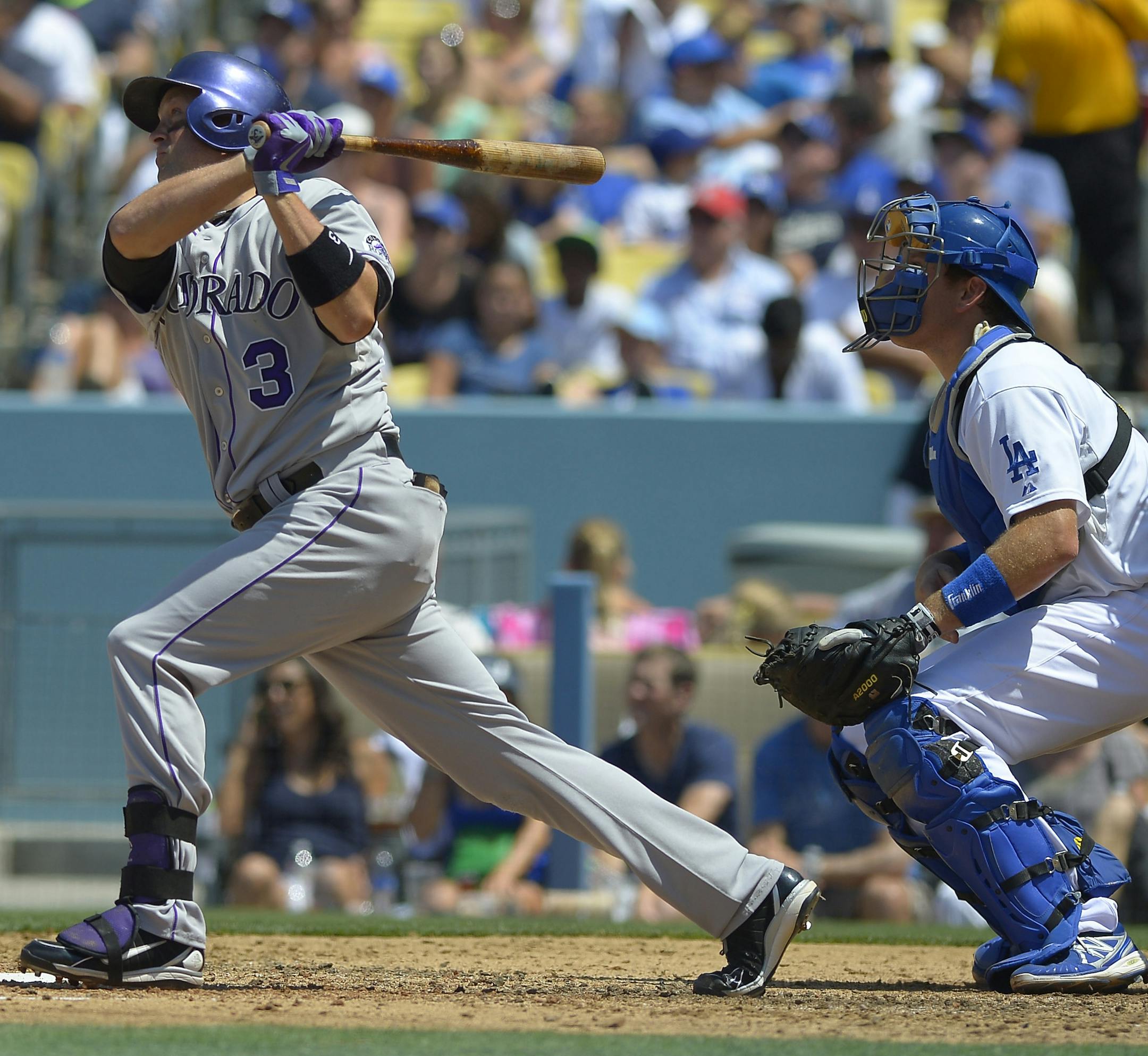Colorado Rockies' Michael Cuddyer, left, hits a two-run home run as Los Angeles Dodgers catcher A.J. Ellis looks on during the fifth inning of a baseball game on Sunday, July 14, 2013, in Los Angeles. (AP Photo/Mark J. Terrill)