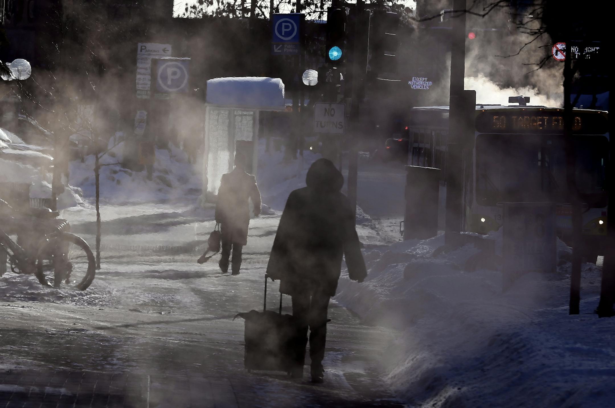 A woman walked through the steamed sidewalks near Minneapolis Central Library in the frigid cold Monday January 27, 2014 in Minneapolis ,MN.