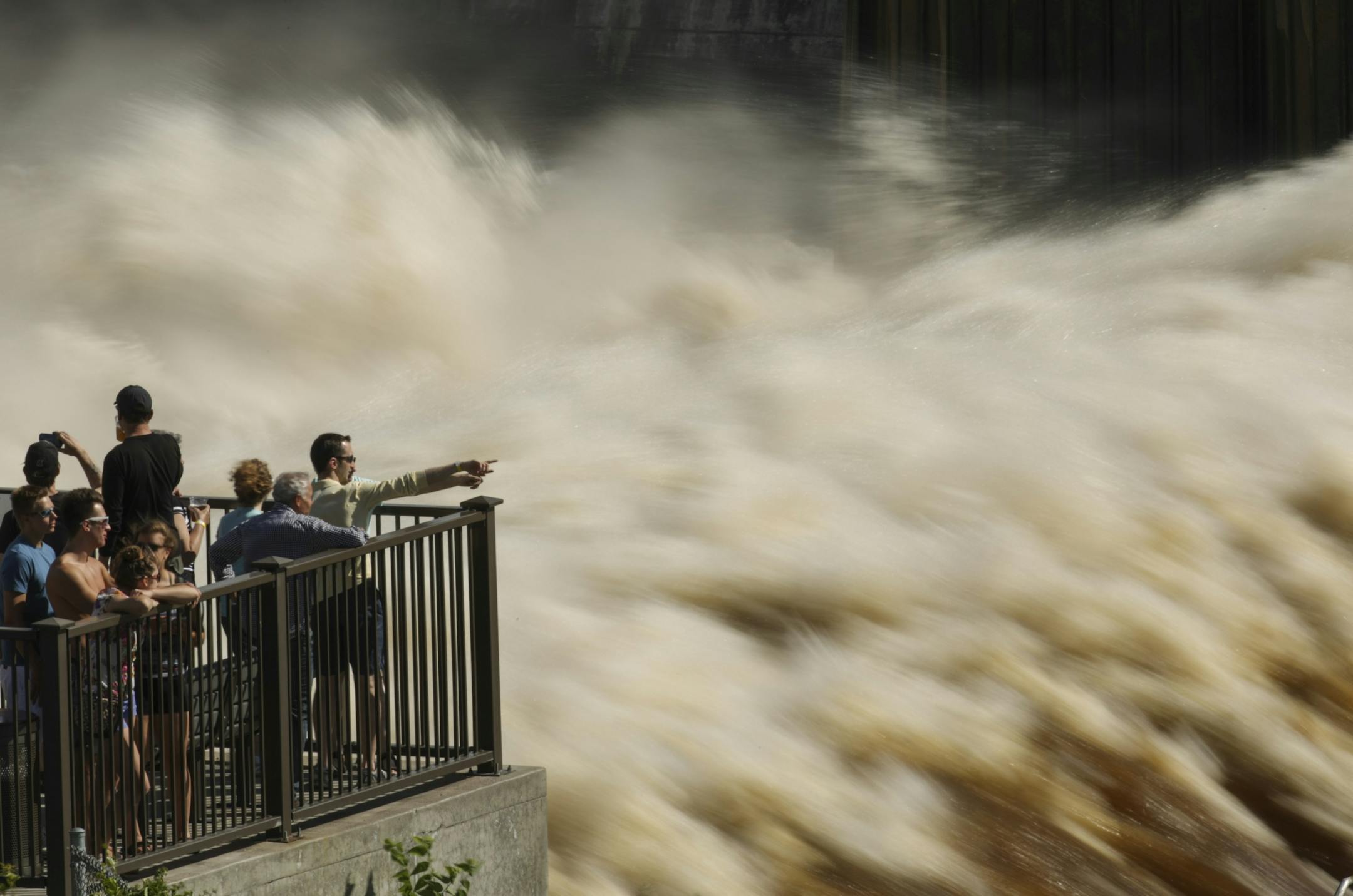 A steady crowd gathered to view the turbulant water flow at St. Anthony Falls from the observation platform at Water Power Park Sunday afternoon.