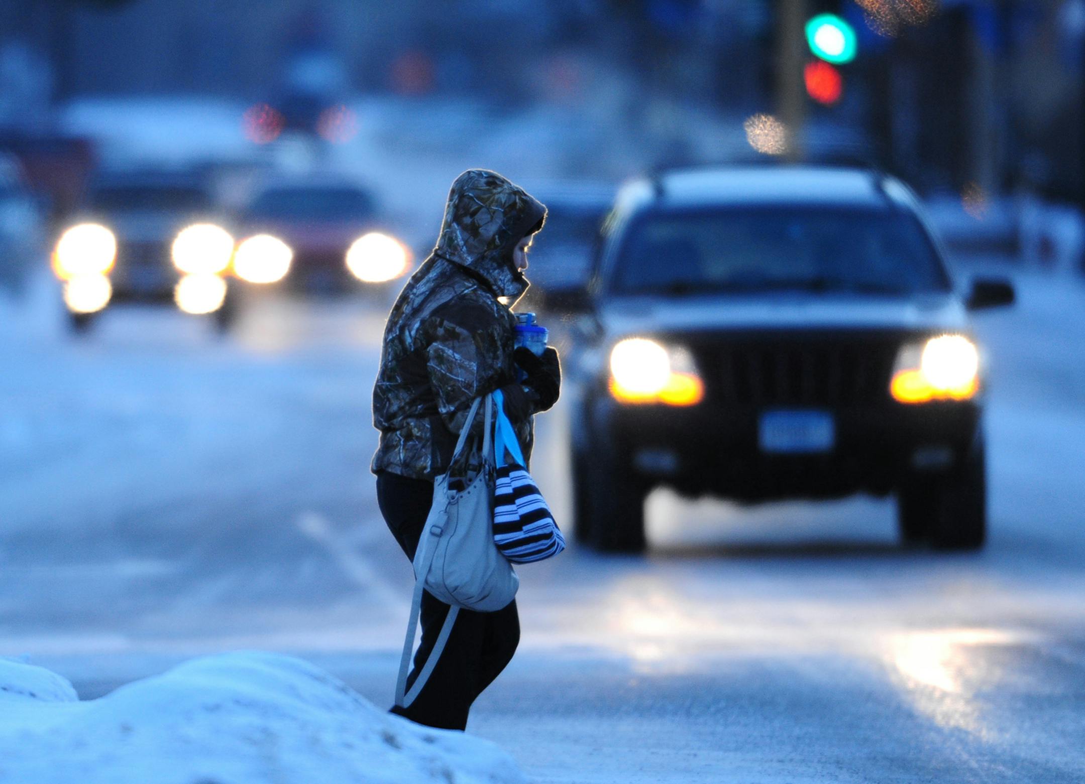 Bundled agaibnst the cold, A woman crosses Laurel Street in Brainerd, Minn., Monday morning Jan. 6, 2014. Minnesota schools were closed Monday because of the expected cold temperatues. Temperatures were -20 degrees below zero with moderate winds. (AP Photo/brainerddispatch, Steve Kohls) (AP Photo/The Brainerd Daily Dispatch, Steve Kohls) ORG XMIT: MIN2014012912032149