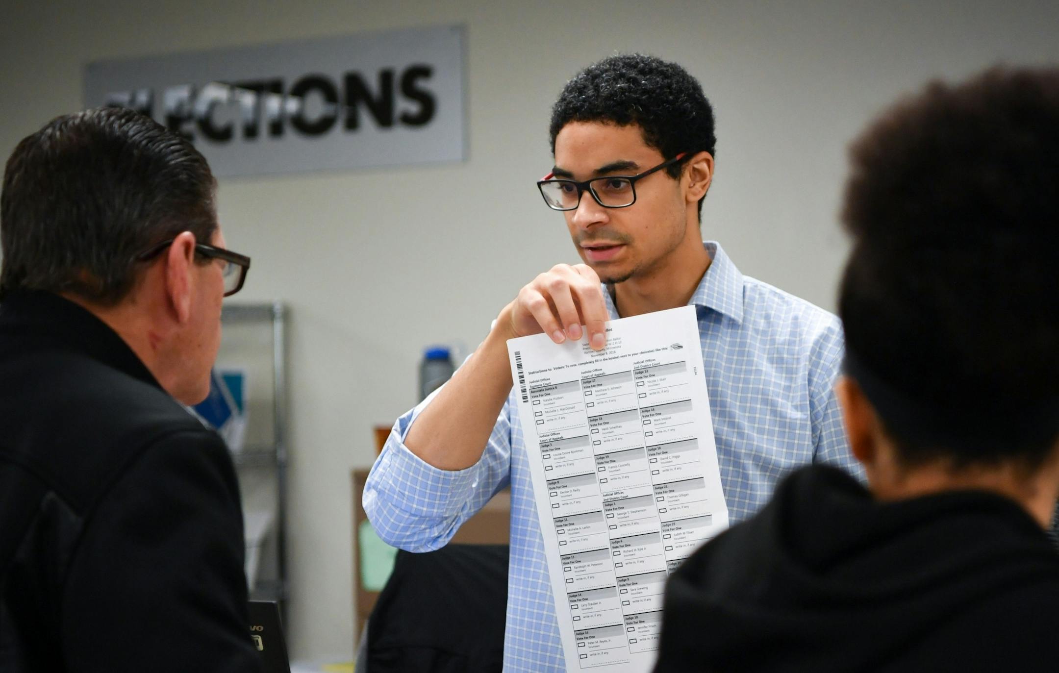 Election assistant Shane McSparrow explained the voting proceedure to a voter on the last day of early voting in St. Paul.