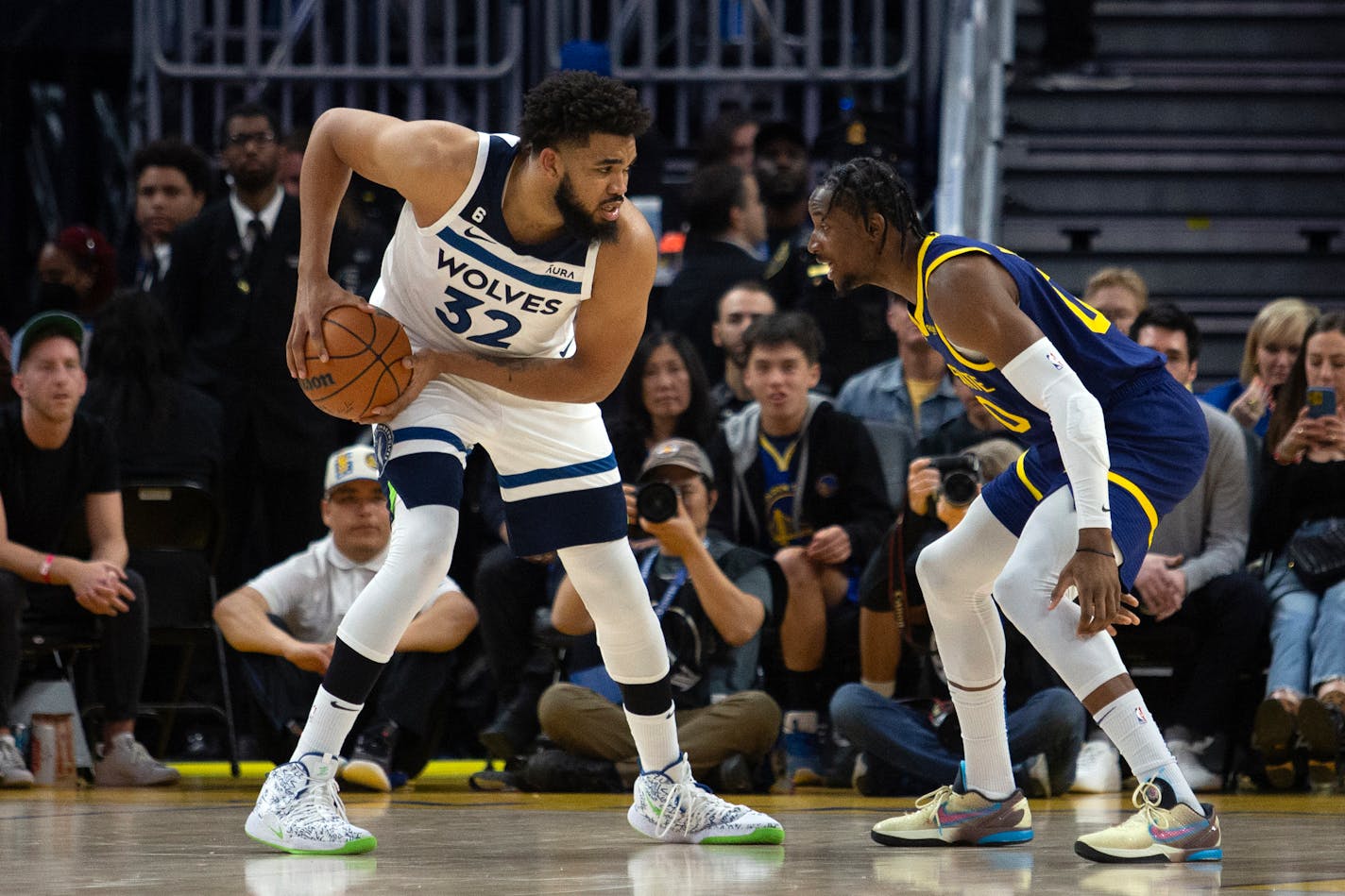 Minnesota Timberwolves forward Karl-Anthony Towns (32) looks to drive around Golden State Warriors forward Jonathan Kuminga (00) during the third quarter of an NBA basketball game, Sunday, March 26, 2023, in San Francisco. (AP Photo/D. Ross Cameron)