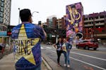 Antone Johnson takes a photo of his fiancee Mona Lisa, right, and Mona’s sister, Myra Russell, center, in front of a Prince mural in downtown Minnea