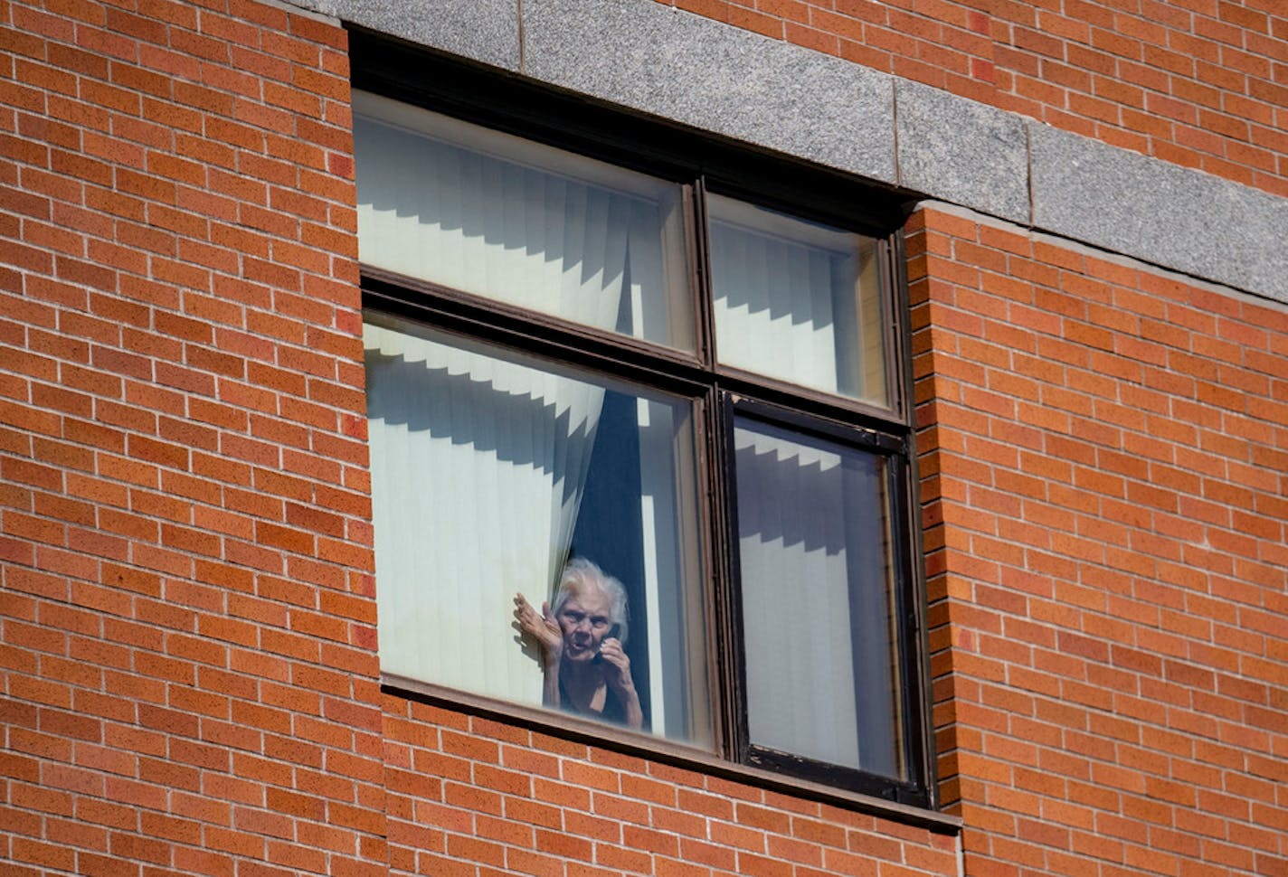 Rose Crist waved down to her daughter, Deana Walkowiak-Olson, from her fourth-floor window at St. Ann's Residence in Duluth in April.