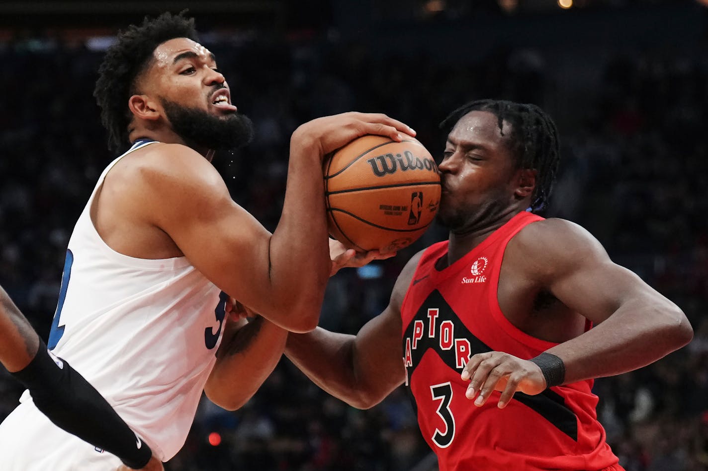 Minnesota Timberwolves' Karl-Anthony Towns (32) hits Toronto Raptors' O.G. Anunoby (3) on the face with the ball as he drives to the basket during the second half of an NBA basketball game Wednesday, Oct. 25, 2023, in Toronto. (Nathan Denette/The Canadian Press via AP)