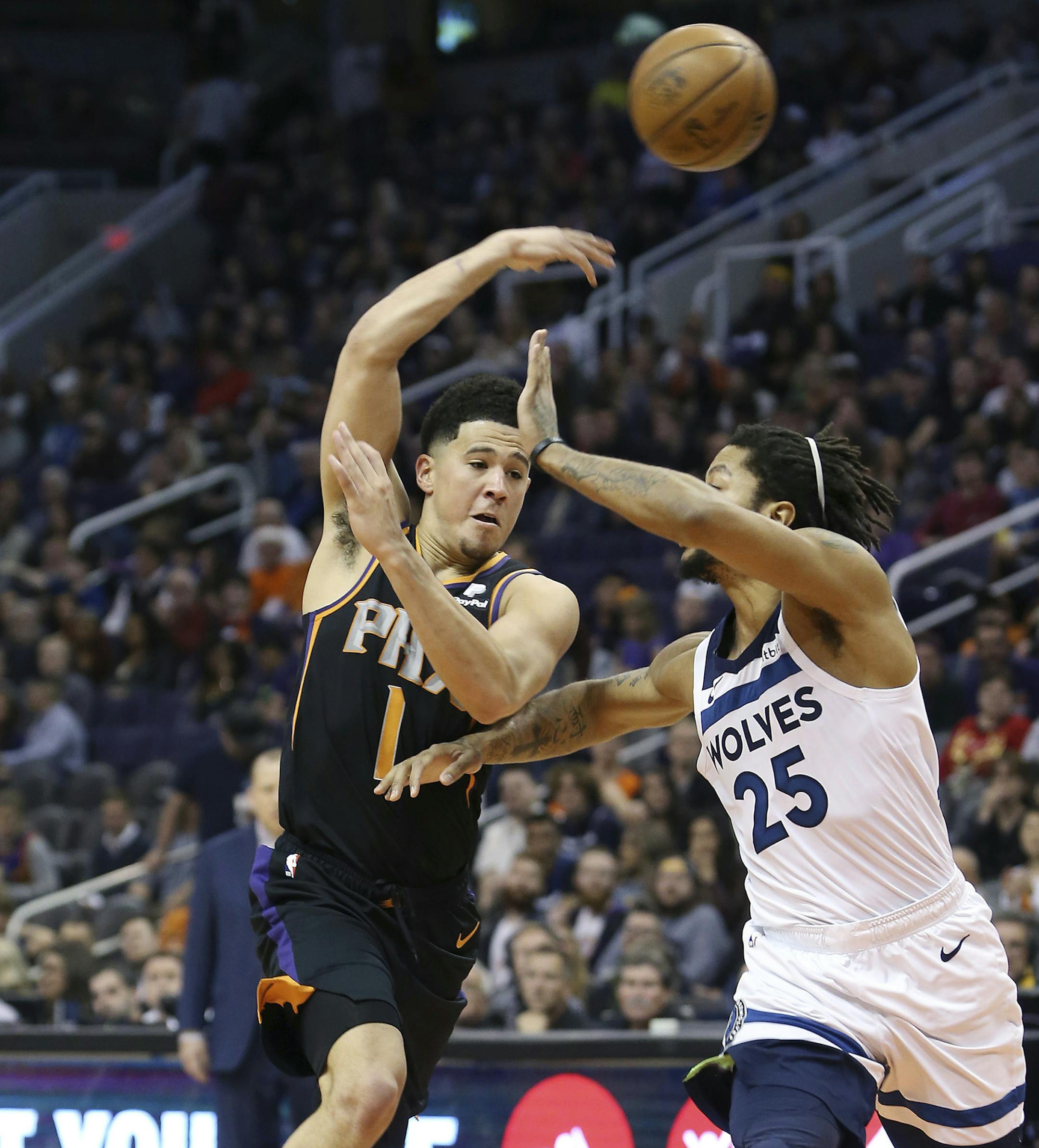 Phoenix Suns guard Devin Booker (1) makes a no-look pass over the defense of Minnesota Timberwolves' Derrick Rose during the second half of an NBA basketball game, Saturday, Dec. 15, 2018, in Phoenix. (AP Photo/Ralph Freso)