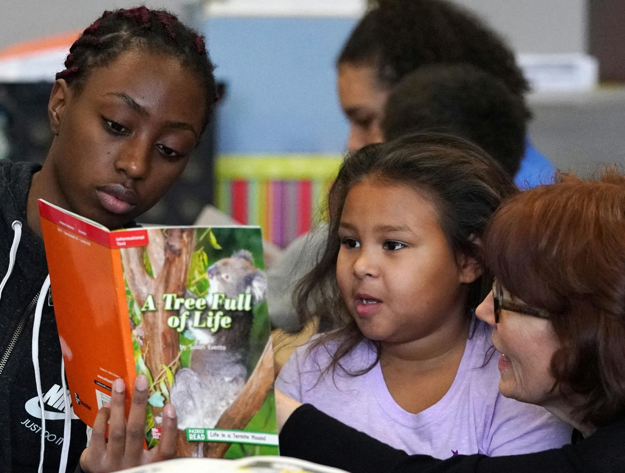 Denfeld junior Kamarie Stringer and teacher Kim Hardwig read with Jackie Schlais.