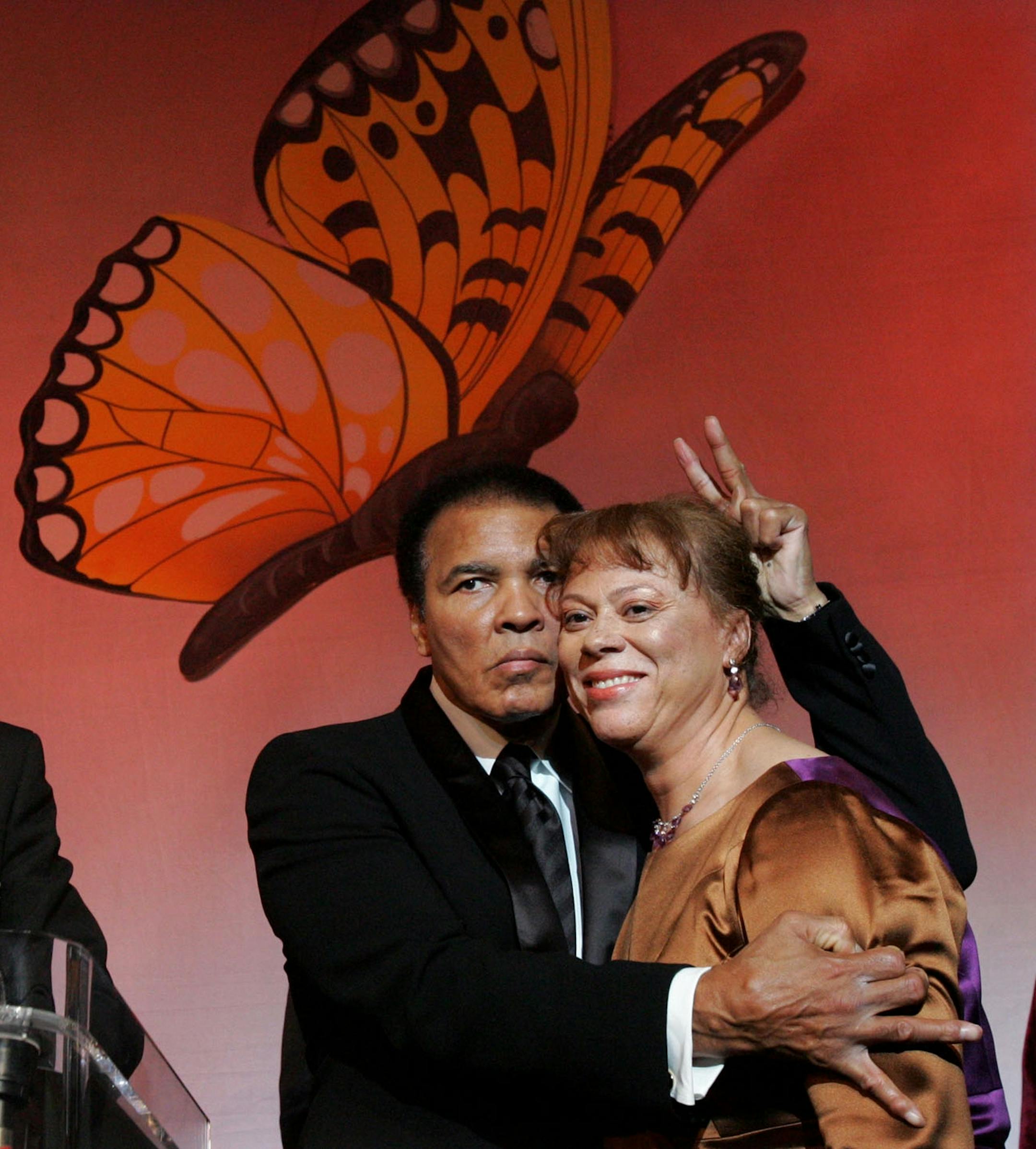 Muhammad Ali playfully sneaks two fingers behind the head of his wife, Lonnie, as the Rev. Jesse Jackson looks on during the Butterfly Ball, a tribute honoring Ali and coinciding with Black History Month, Saturday, Feb. 26, 2005, in Atlanta.