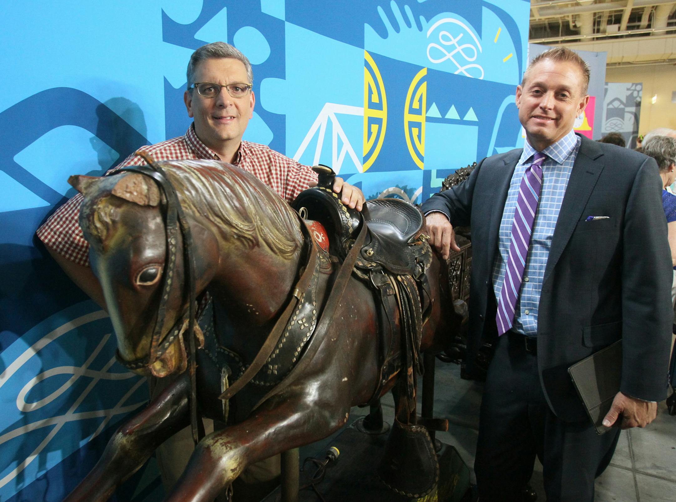 Craig Webb, Akron Beacon Journal Metro editor, poses with appraiser Brian Witherell and his mechanical horse on the set of the Antiques Roadshow 2015 summer tour in Cleveland, Ohio, on Saturday, July 11, 2015. (Mike Cardew/Akron Beacon Journal/TNS)