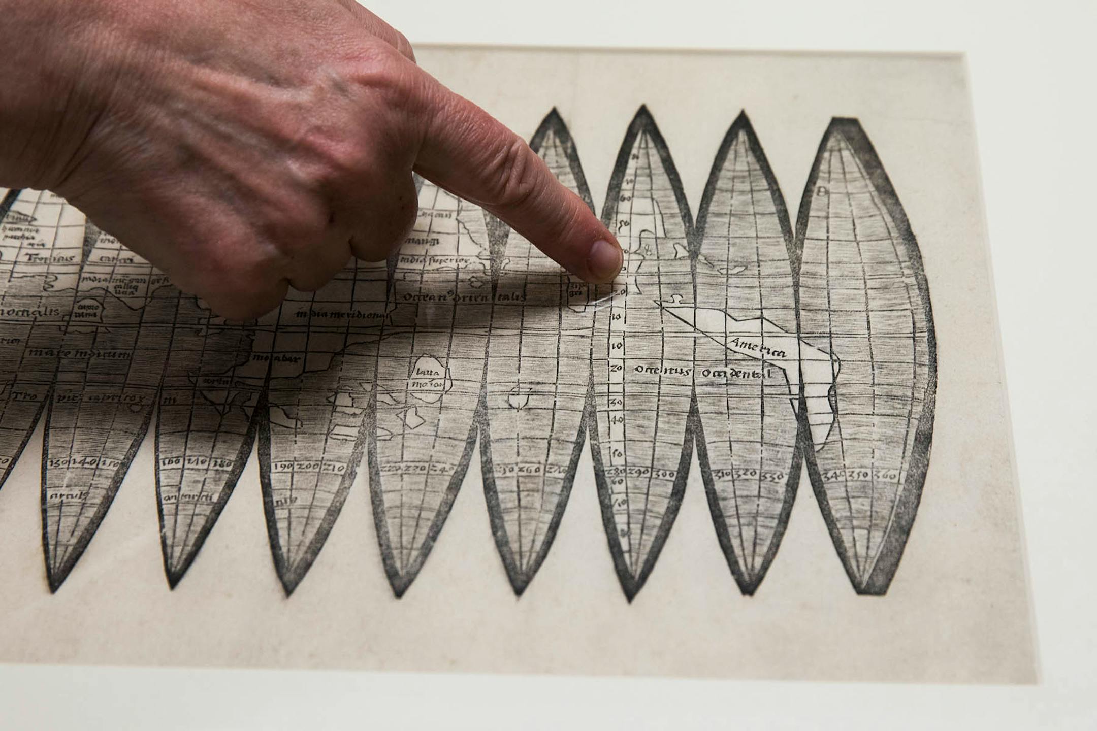 Marguerite Ragnow, curator of the James Ford Bell Library, points to the first mention of America on the 1507 globe gores map.