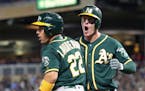 Oakland Athletics' Ramon Laureano, left, and Mark Canha celebrate after they scored on a two-run double by Chris Davis off Minnesota Twins relief pitc